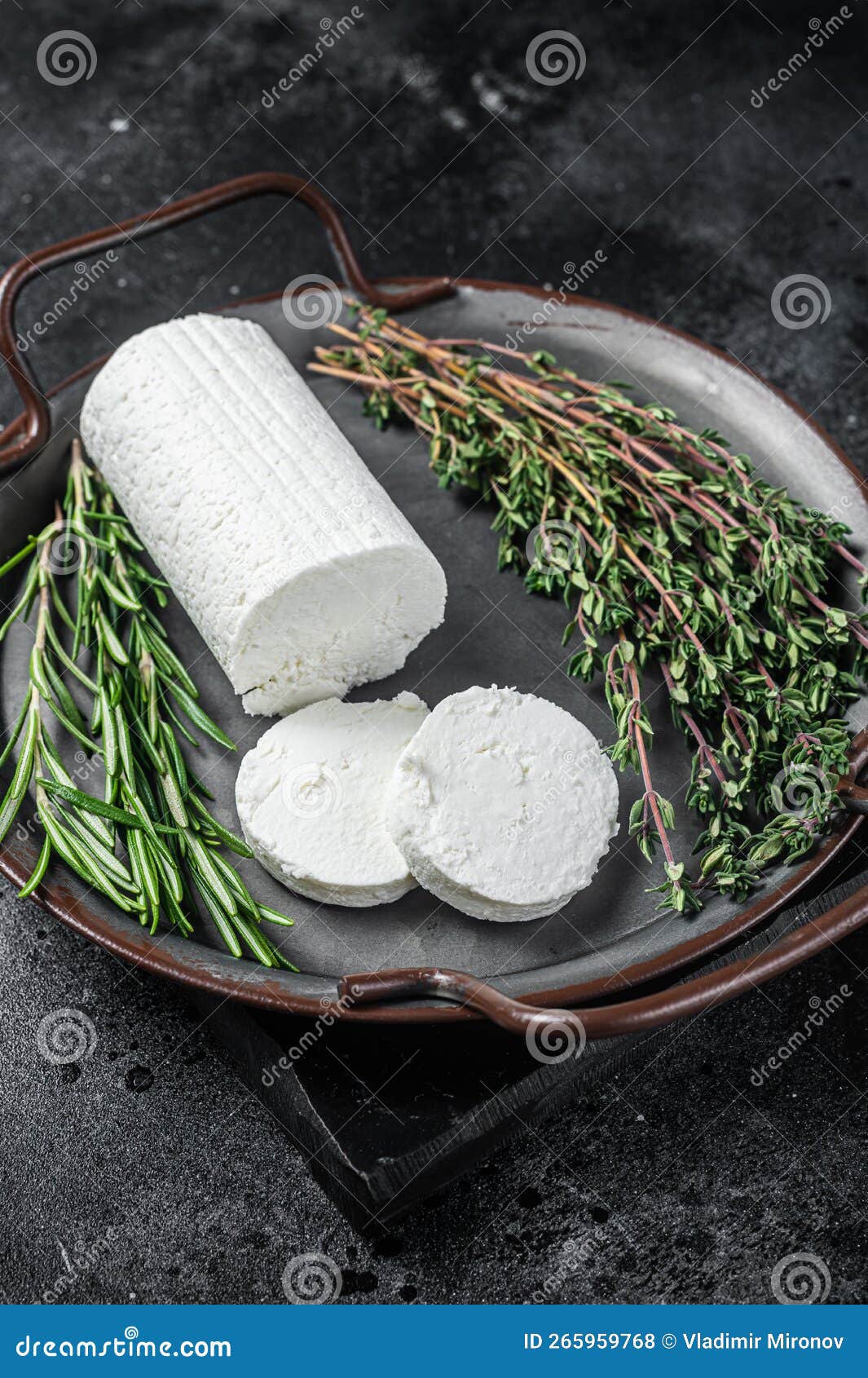 Chevre Goat Soft Cheese with Herbs on a Tray. Black Background Stock
