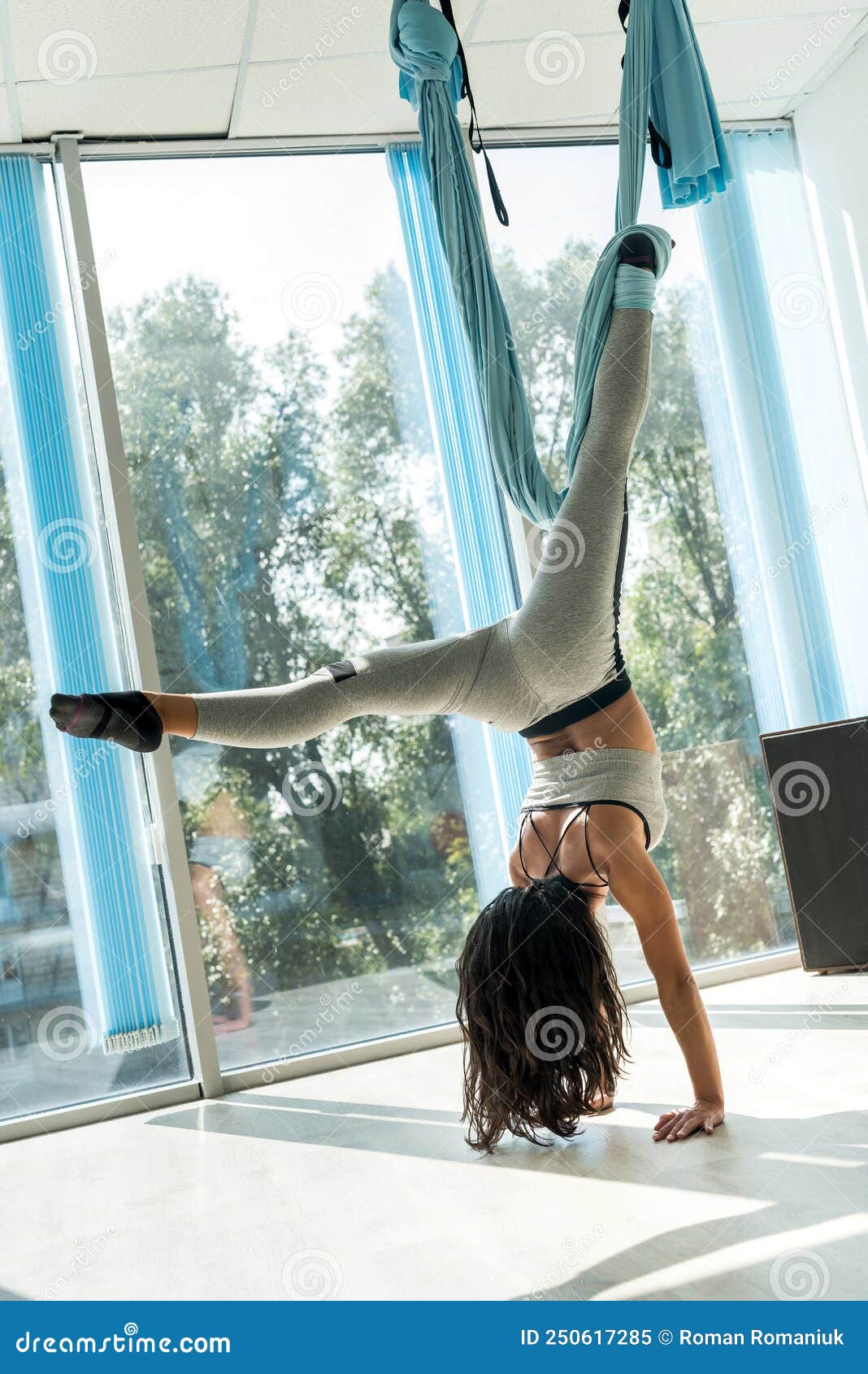 Mujer bonita vistiendo ropa deportiva y haciendo yoga.