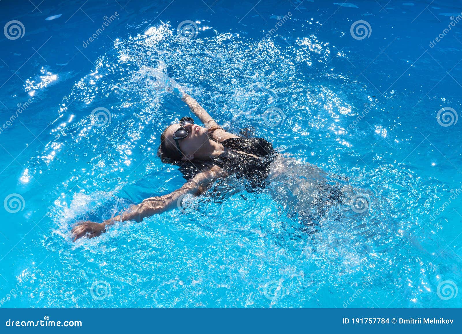 Hermosa mujer con gafas de sol nadando en una piscina