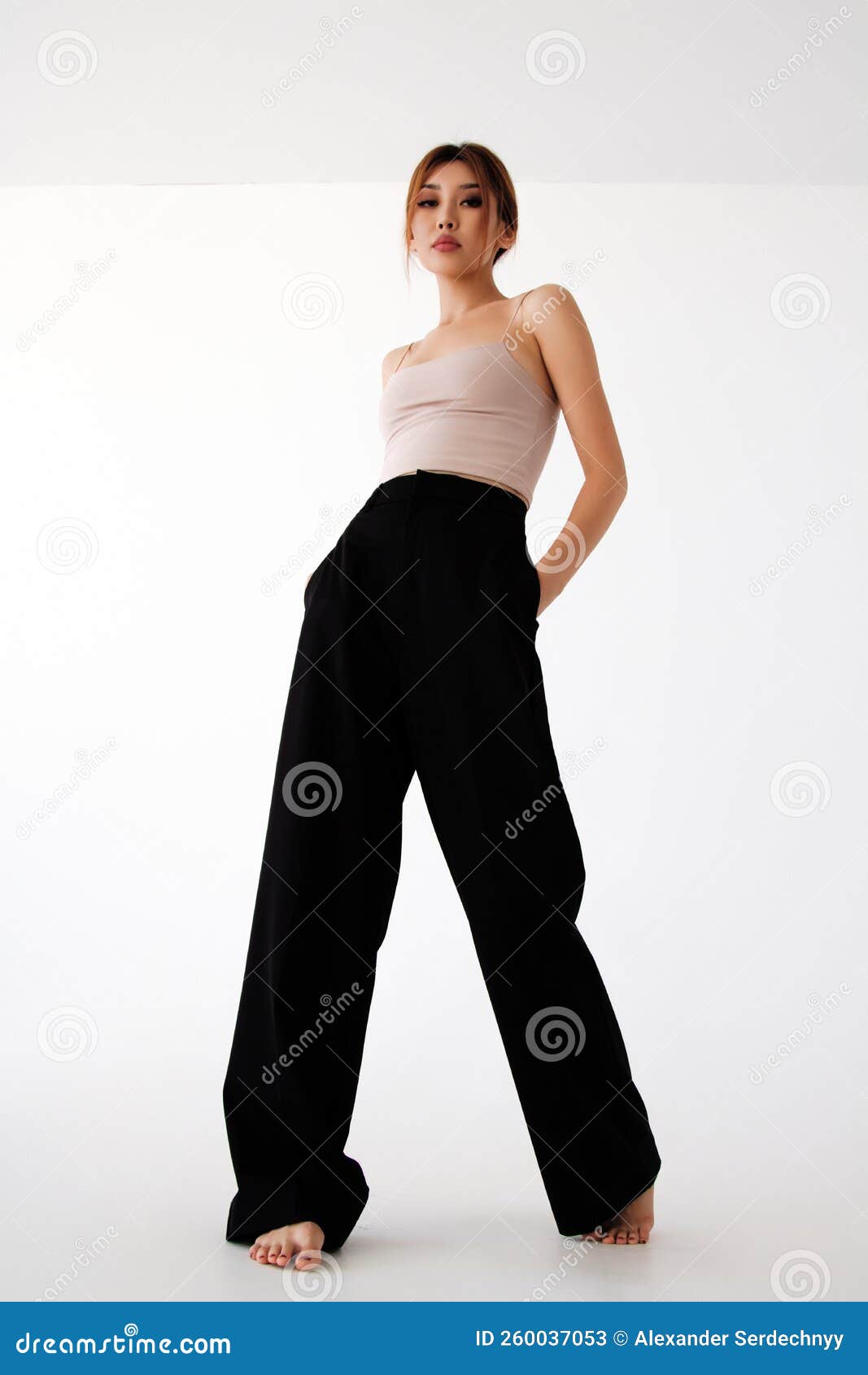 Mujer Joven Delgada Vestida En Pantalones Negros Foto de archivo