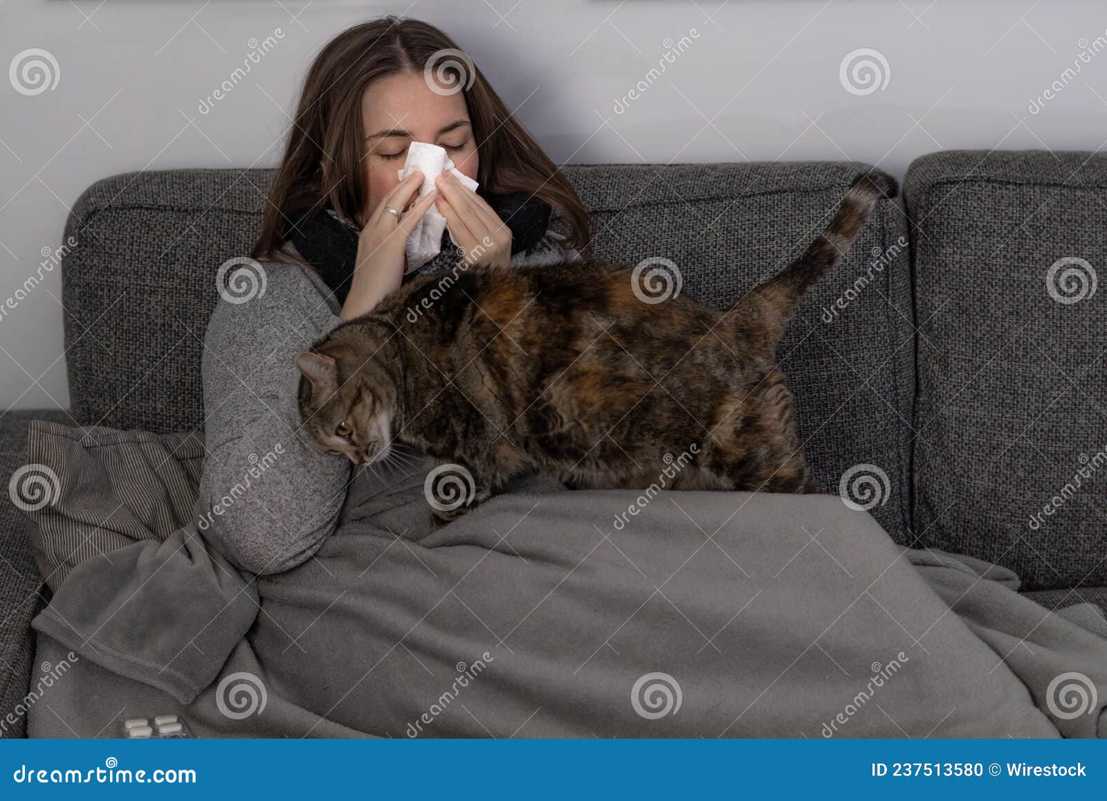 chica joven enferma tumbada en el sofa con su gato