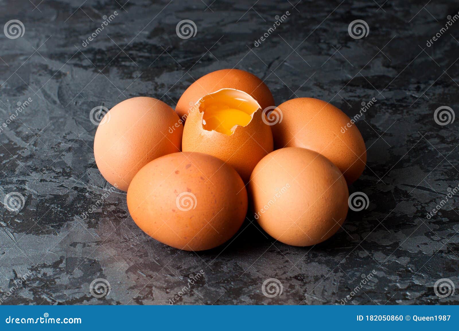 Chicken Eggs on a Dark Gray Background, Visible Orange Yolk Stock Photo