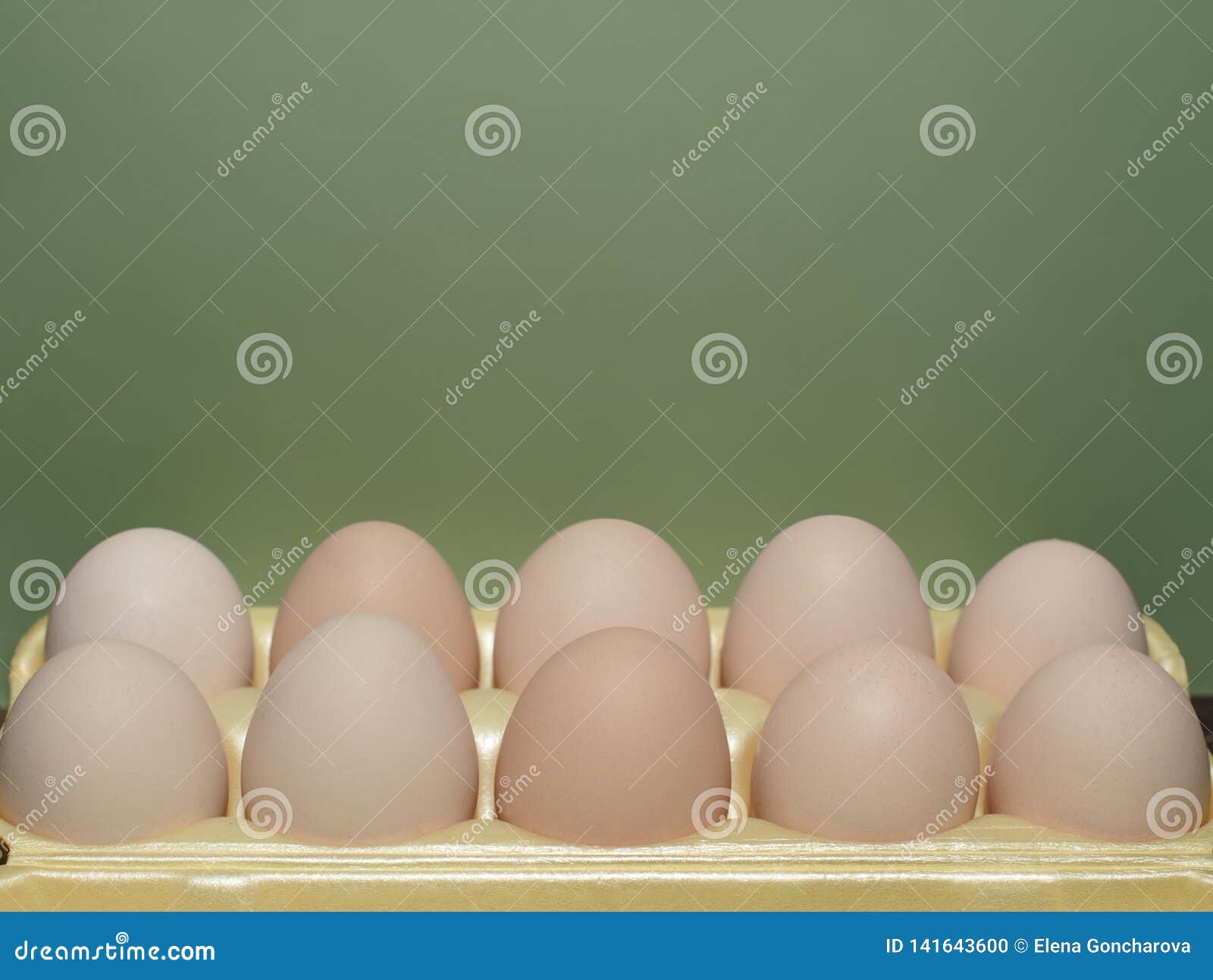 chicken eggs lie in a yellow plastic tray.