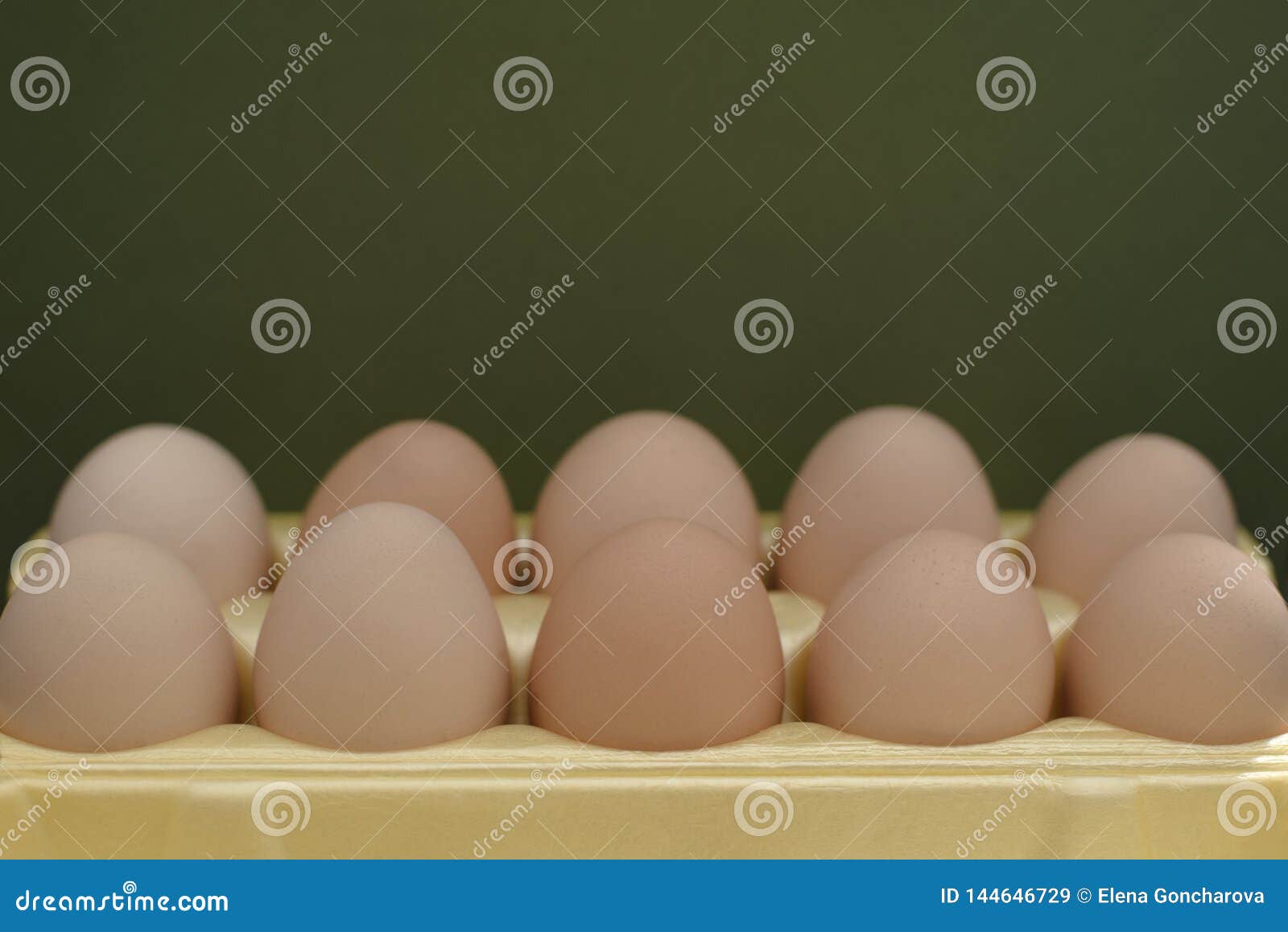 chicken eggs lie in a yellow plastic tray.