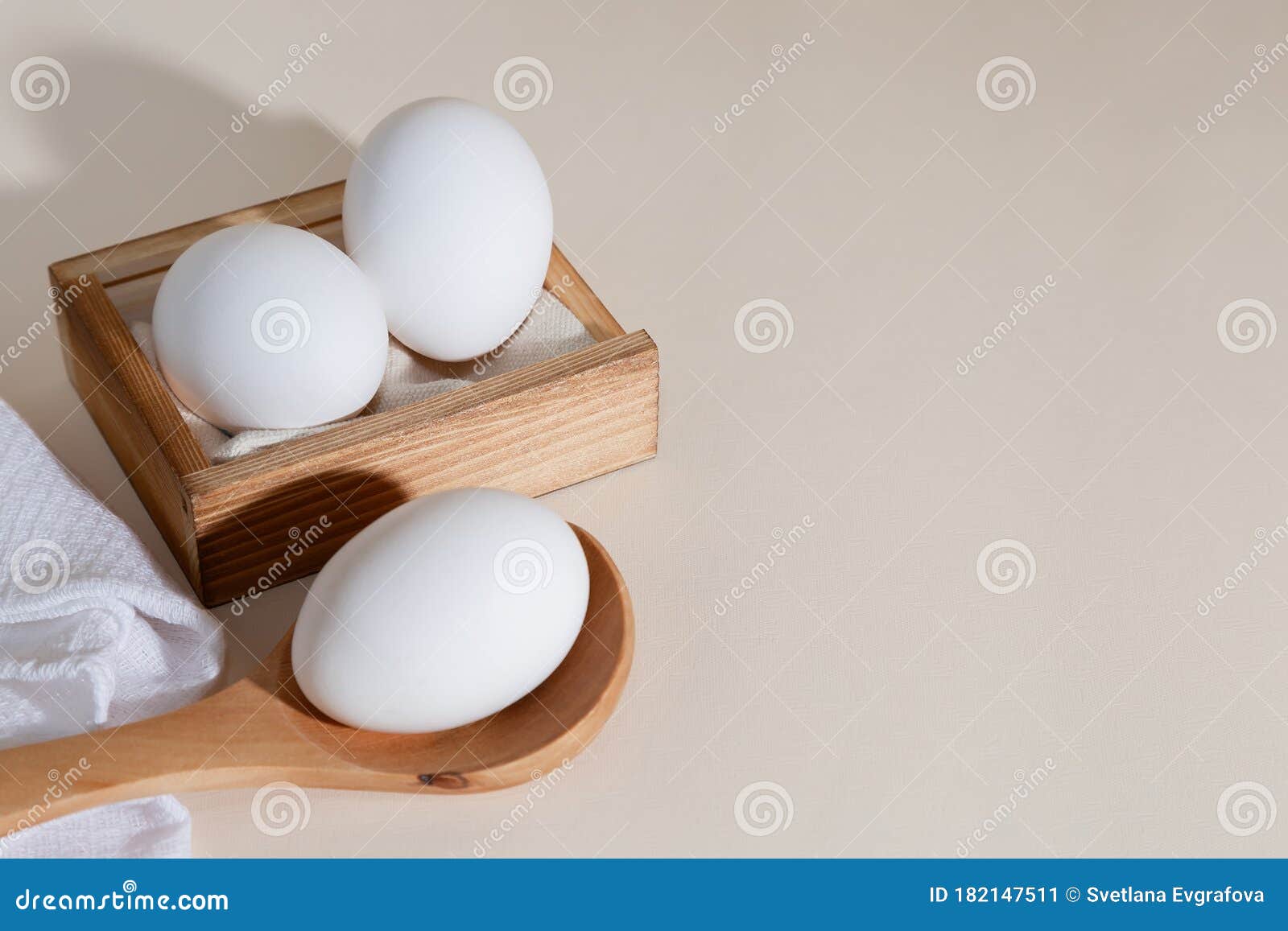 chicken eggs in a wooden box on beige background with copy space, product with amino acids choline lecithin cholesterol calcium