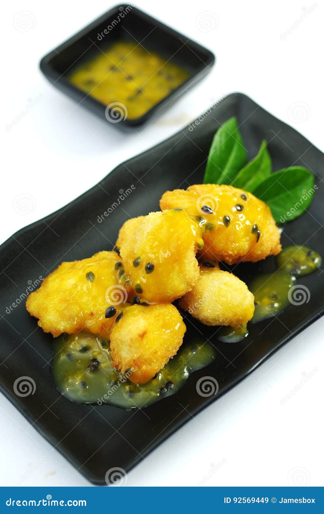 Chicken Fried with Passion Fruit Sauce on Black Platter Stock Image