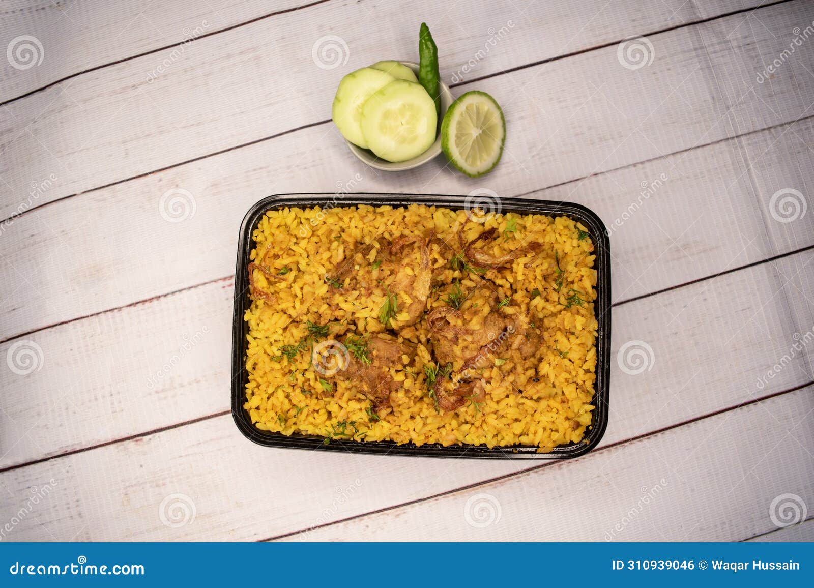 chicken khichuri biryani rice pulao with cucumber and lemon slice served in dish  on wooden table top view of bangladeshi