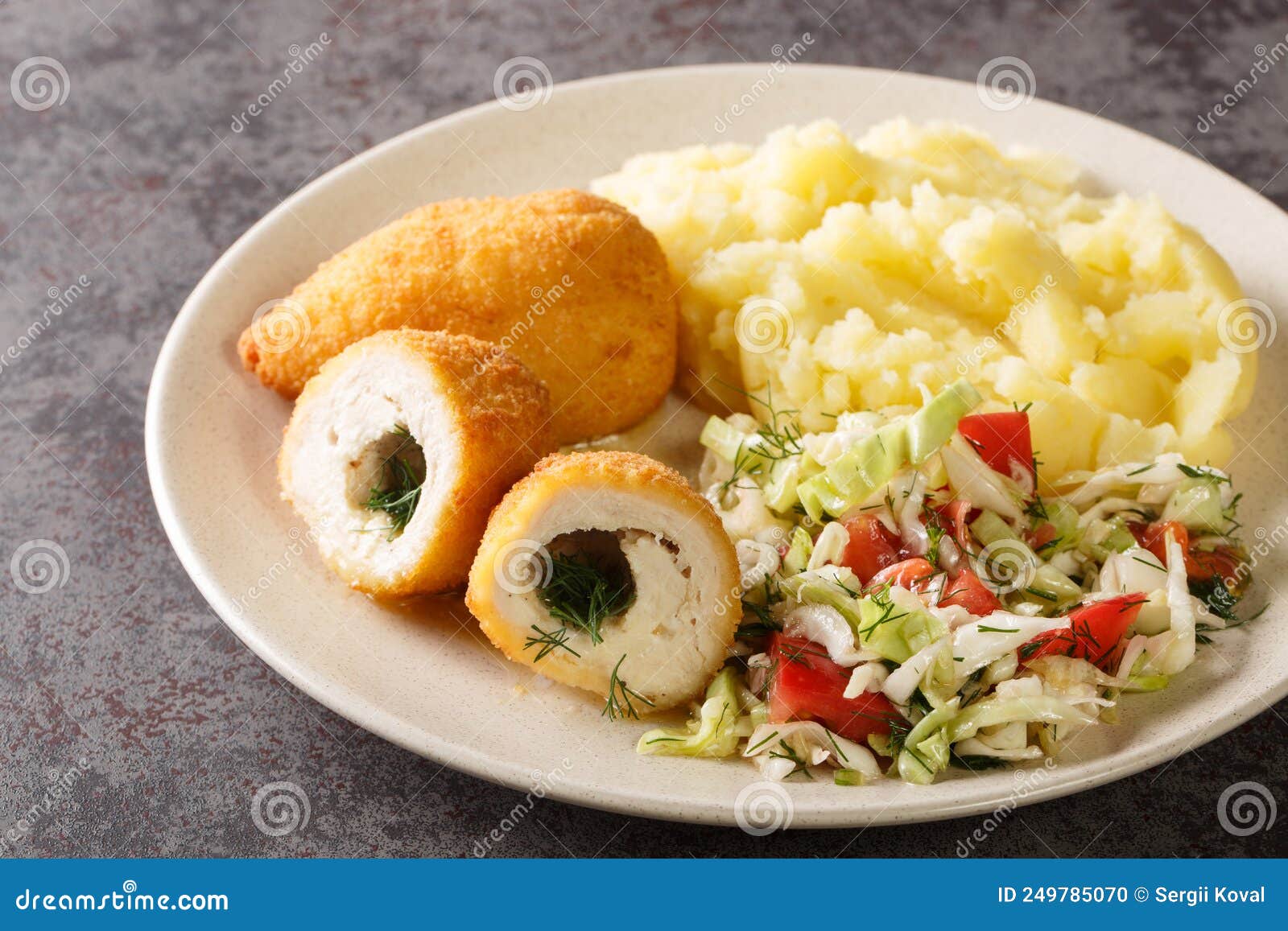 Chicken Kiev Cutlets Served with Salad and Mashed Potatoes Closeup in