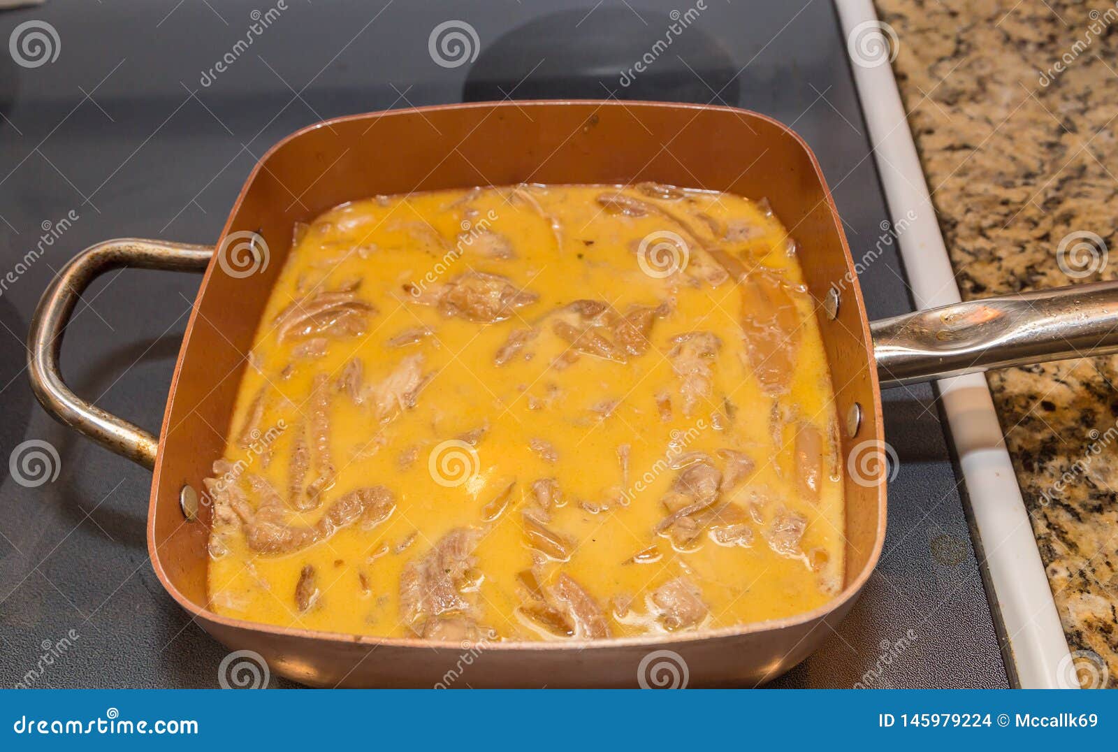 chicken in sauce pan basting in cream sauce