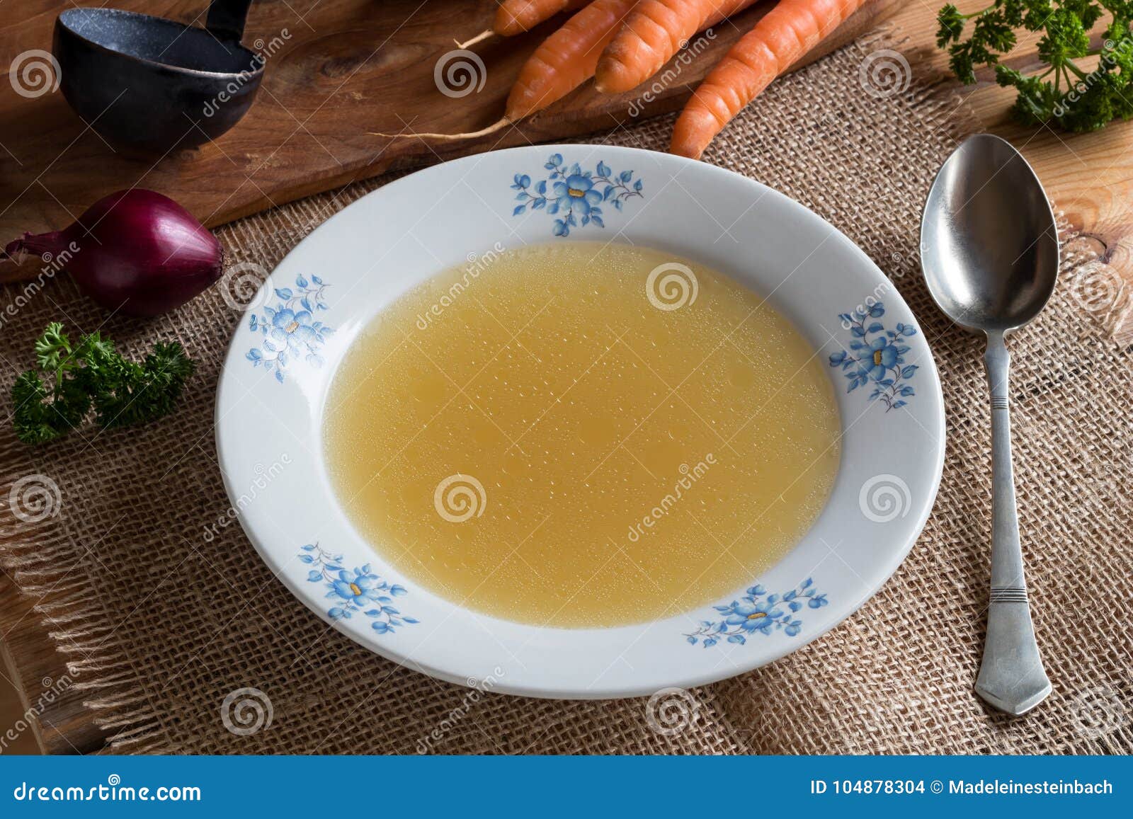 Chicken Stock in a White Plate with Vegetables in the Background Stock ...