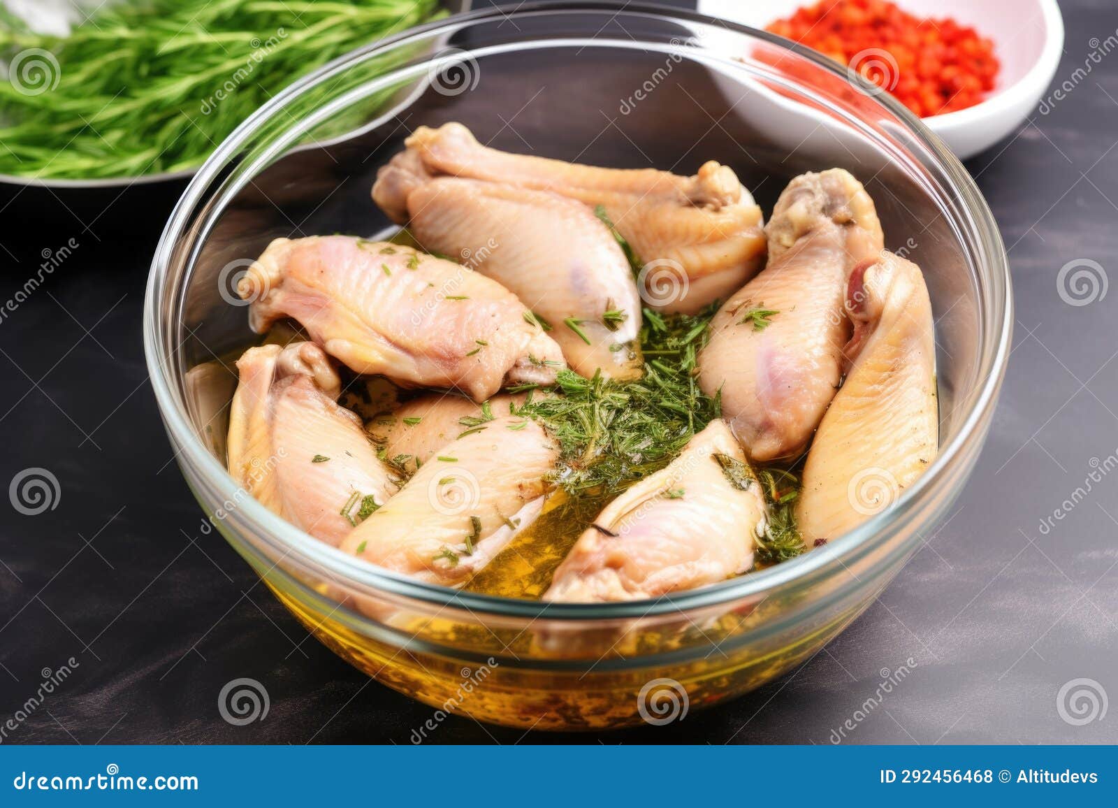 Chicken Wings Marinating in a Bowl with Spices and Herbs Stock Photo