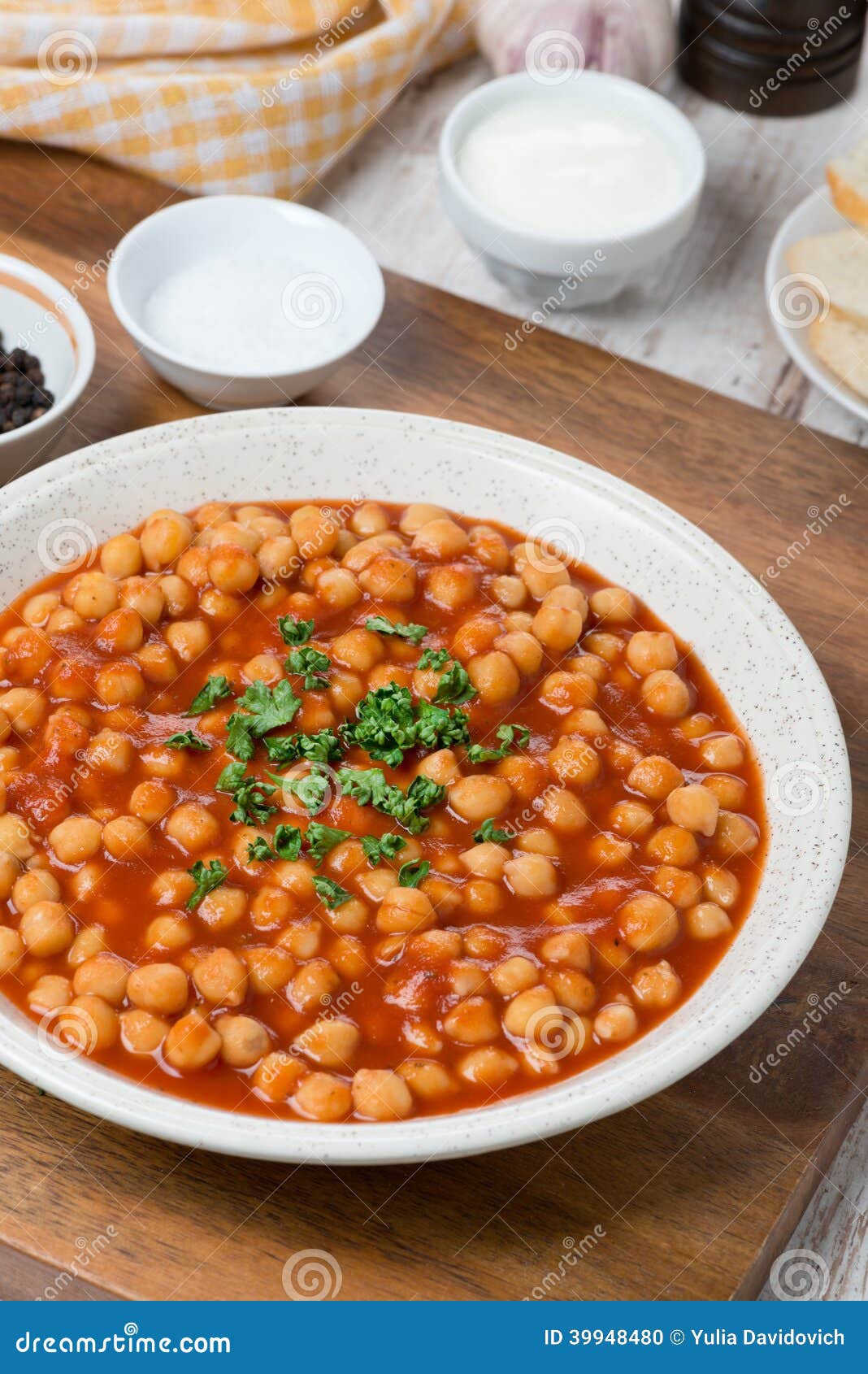 Chickpeas Stewed in Tomato Sauce on a Plate, Vertical Stock Photo
