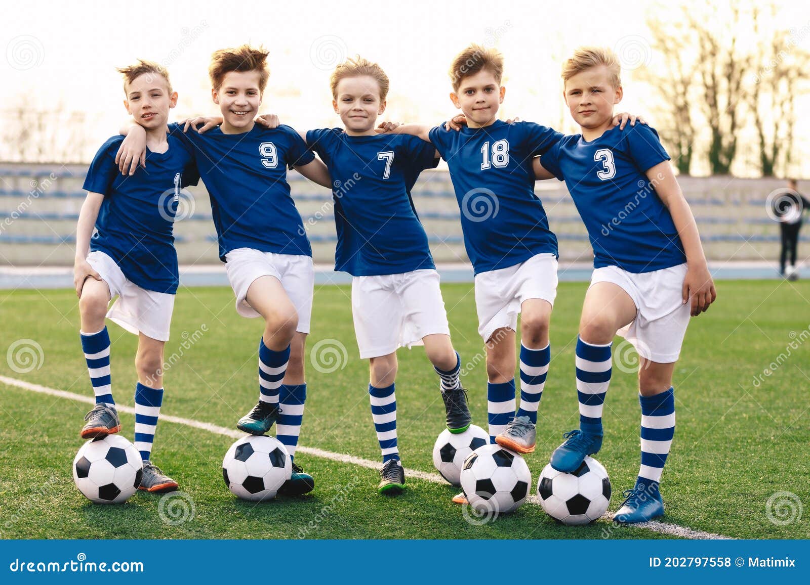 Chicos De Escuela Deportiva En Equipo De Fútbol. Grupo De Niños En Ropa Deportiva De La Camiseta De De Pie Con Bolas En El Foto de archivo - Imagen de