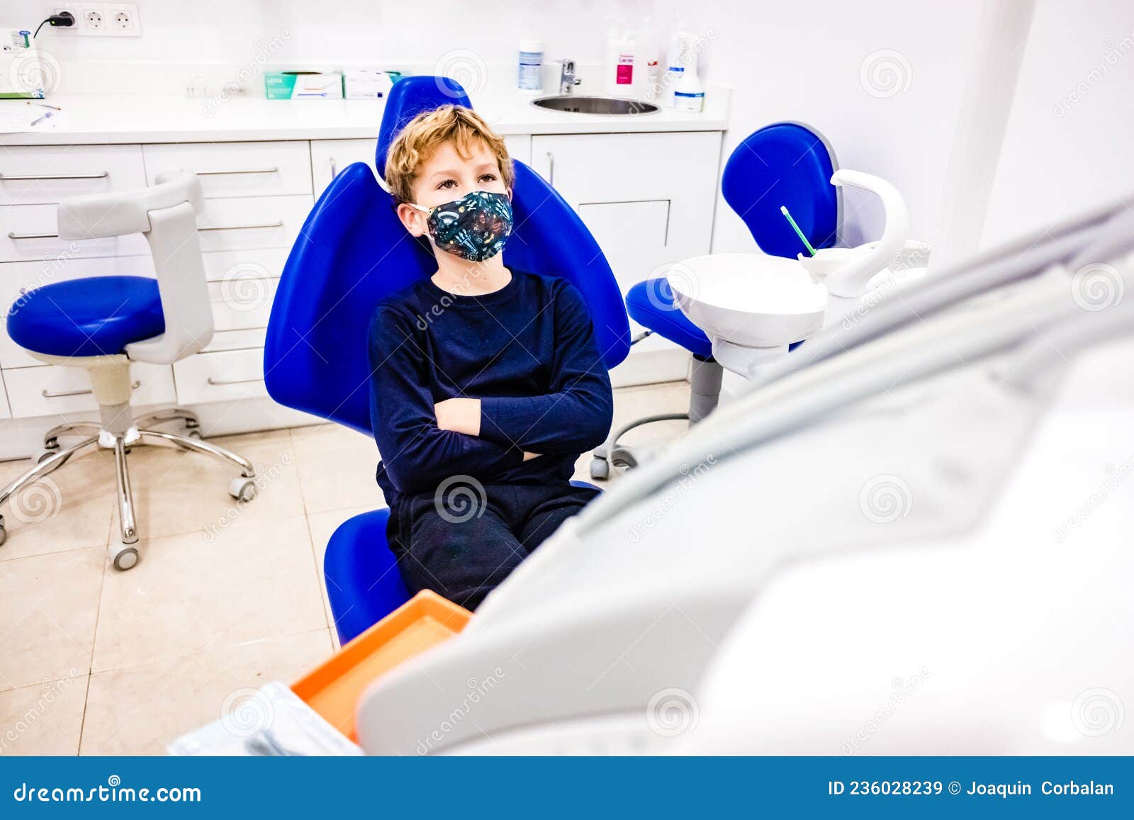 Child with Anticovid Mask Waits in a Dentist Chair To Be Treated Stock