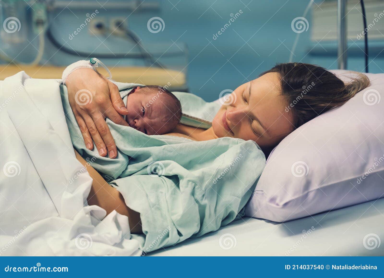 child birth in maternity hospital. mother and newborn. young mom hugging her newborn baby after delivery. woman giving birth