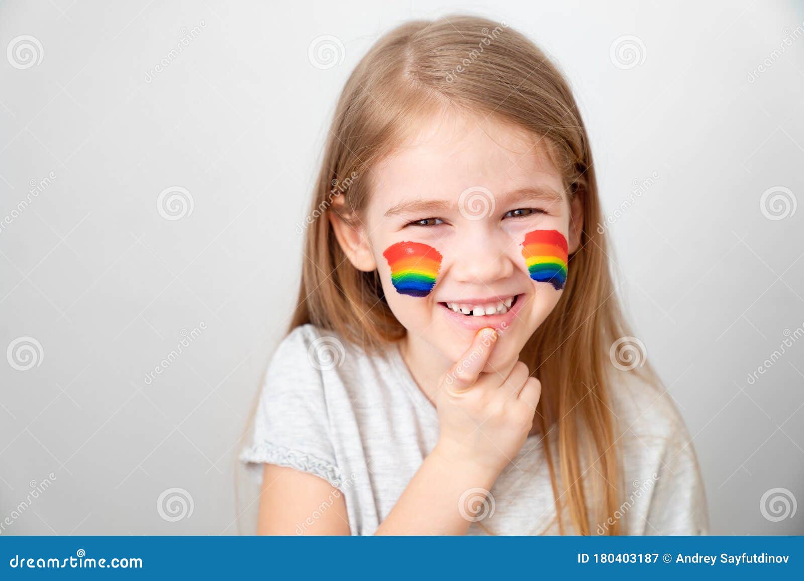 child painted cheeks a rainbow. stay home.