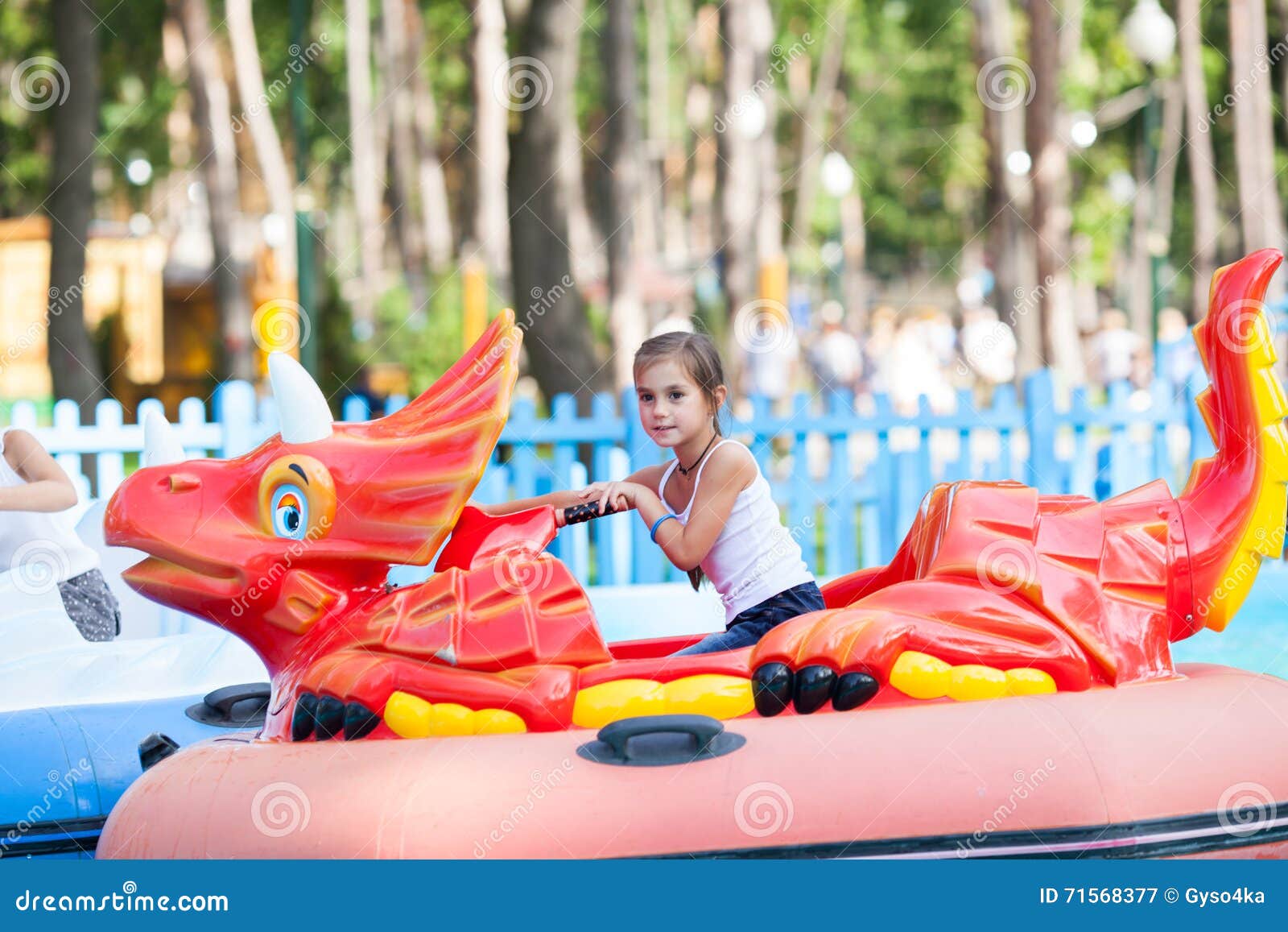 Child on water in the boat - swan rides in the park. Summer holiday.