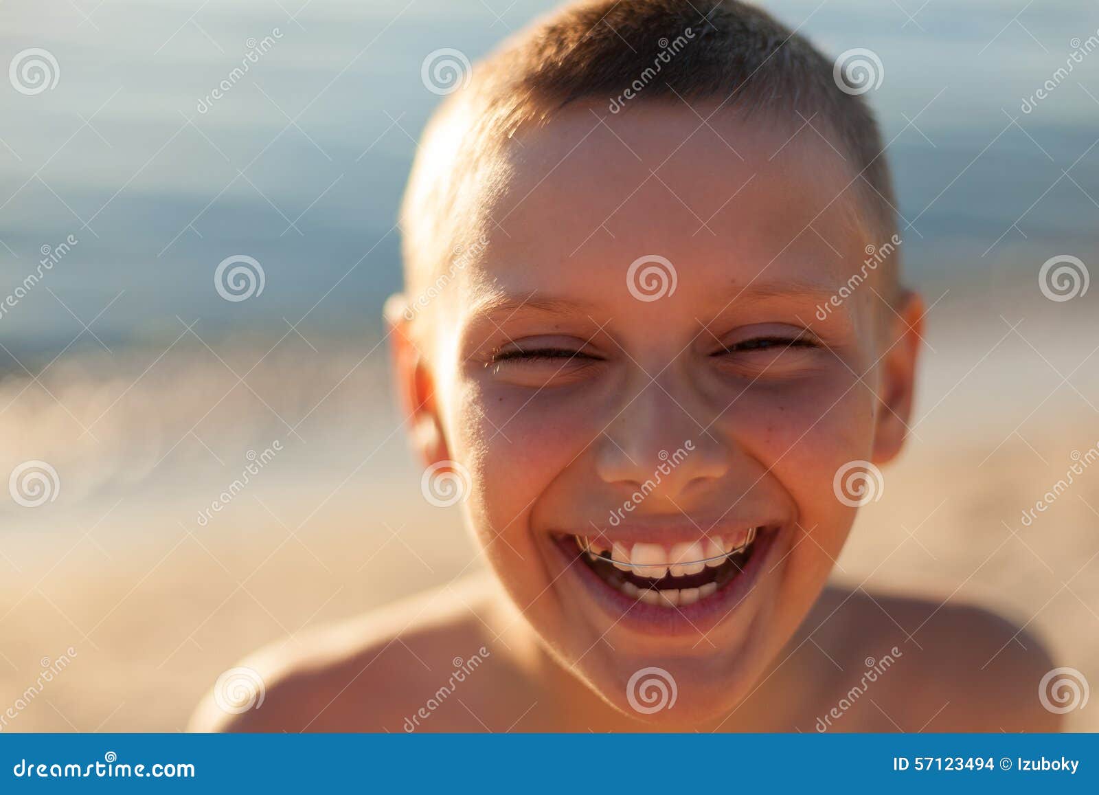 child boy portrait close up sunset backlight happy laughing braces teeth