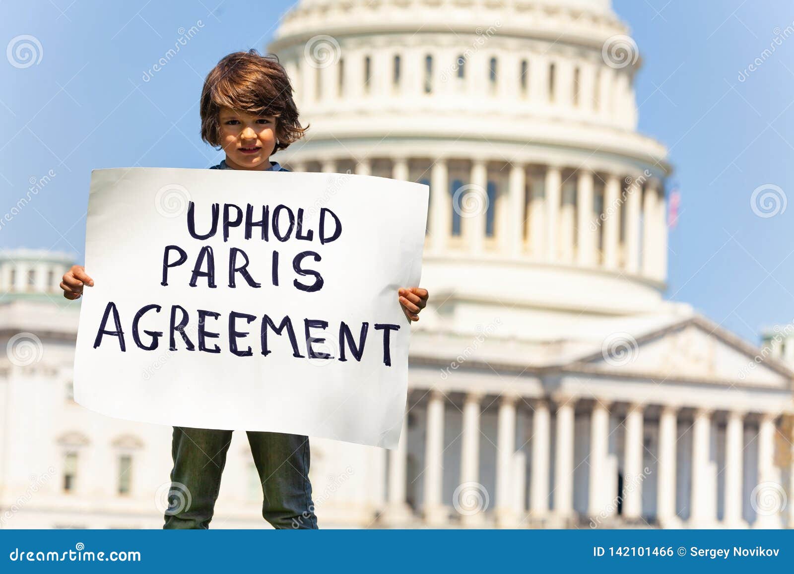protester holding sign uphold paris agreement in hands