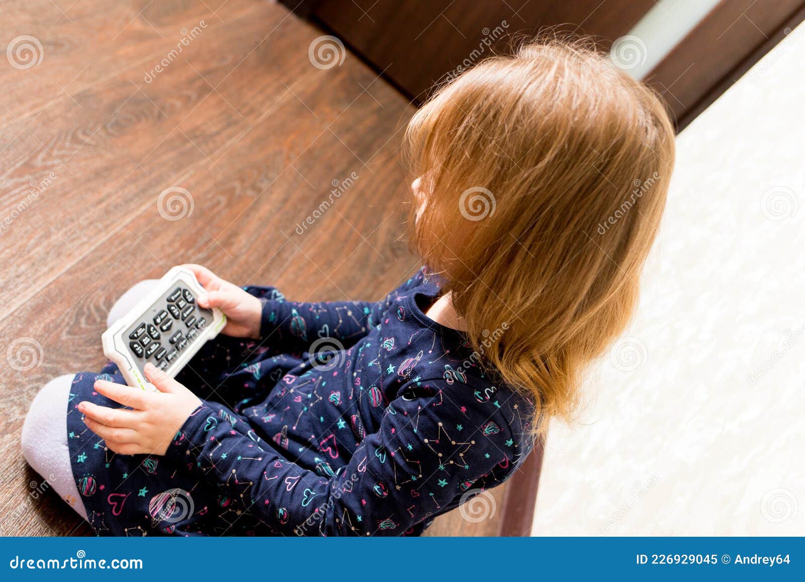 The Child Controls the Robot from the Remote Control Stock Image