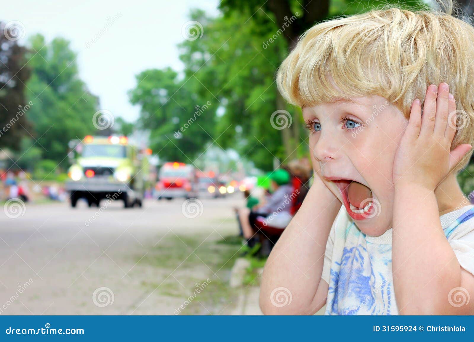 child covering ears at loud parade