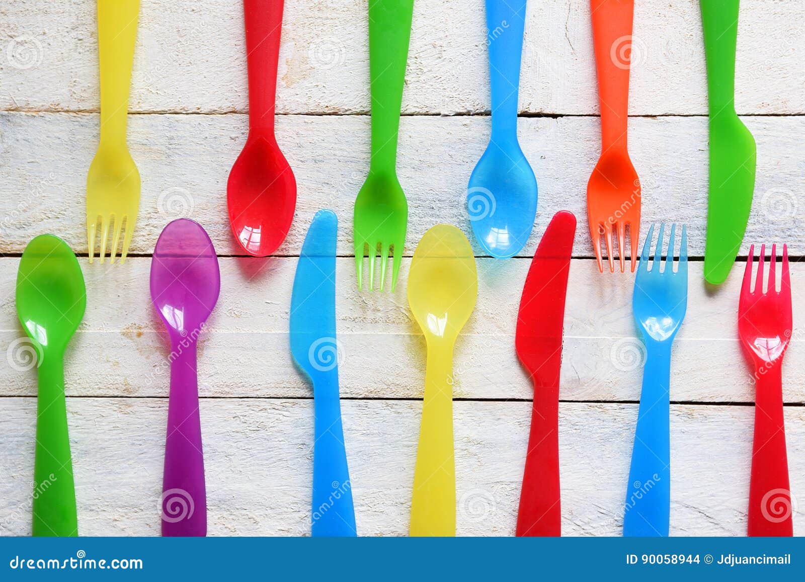 child cutlery on a white wooden table in a kindergarten. colorful flatware