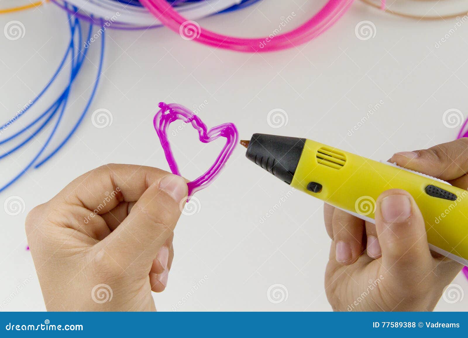 child draw with 3d pen. colourful filaments and white background
