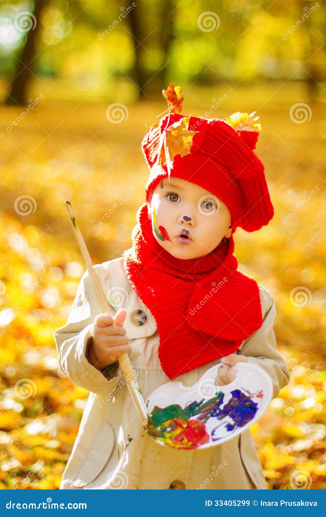 Child painting on easel in Autumn Park. Creative kids development 