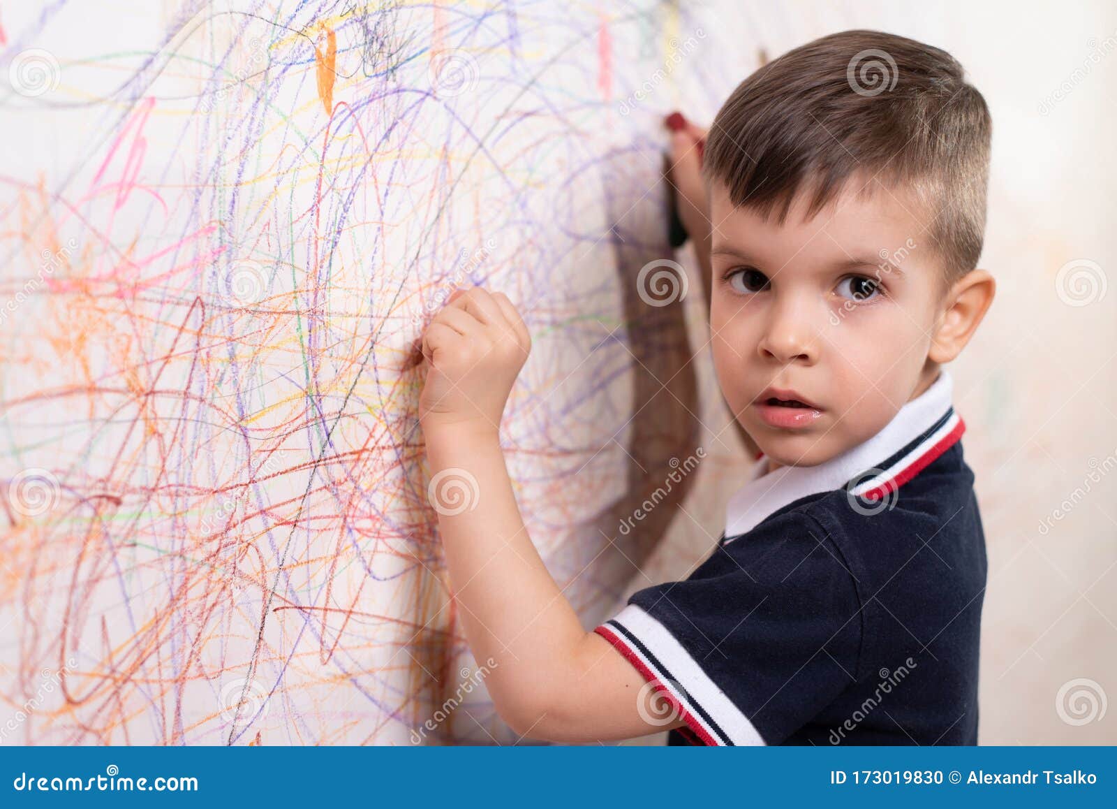 The Child Draws on the Wall with a Crayon. the Boy is Engaged in