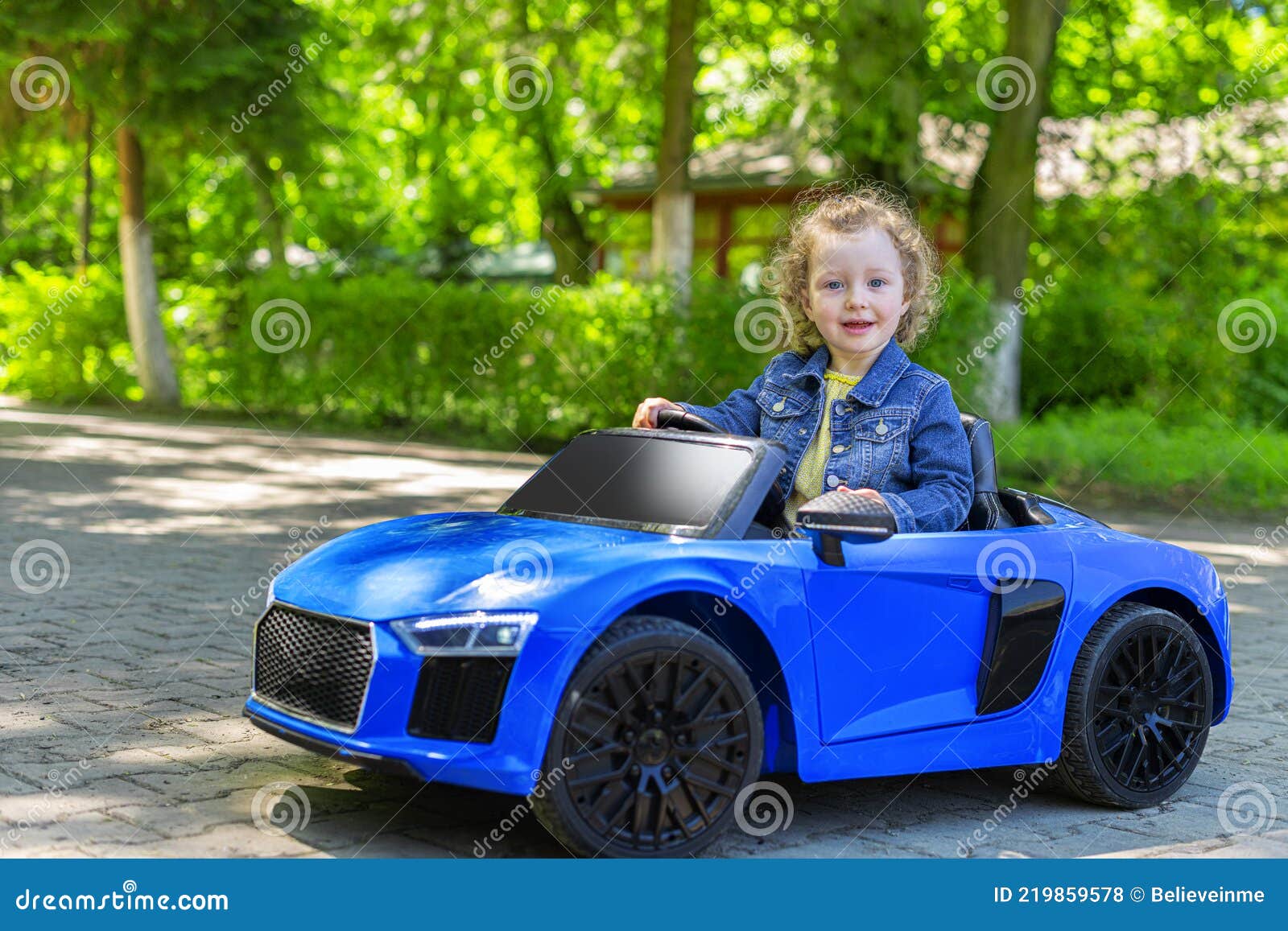 Child is Driving a Toy Car in the Park. Stock Photo Image of tire