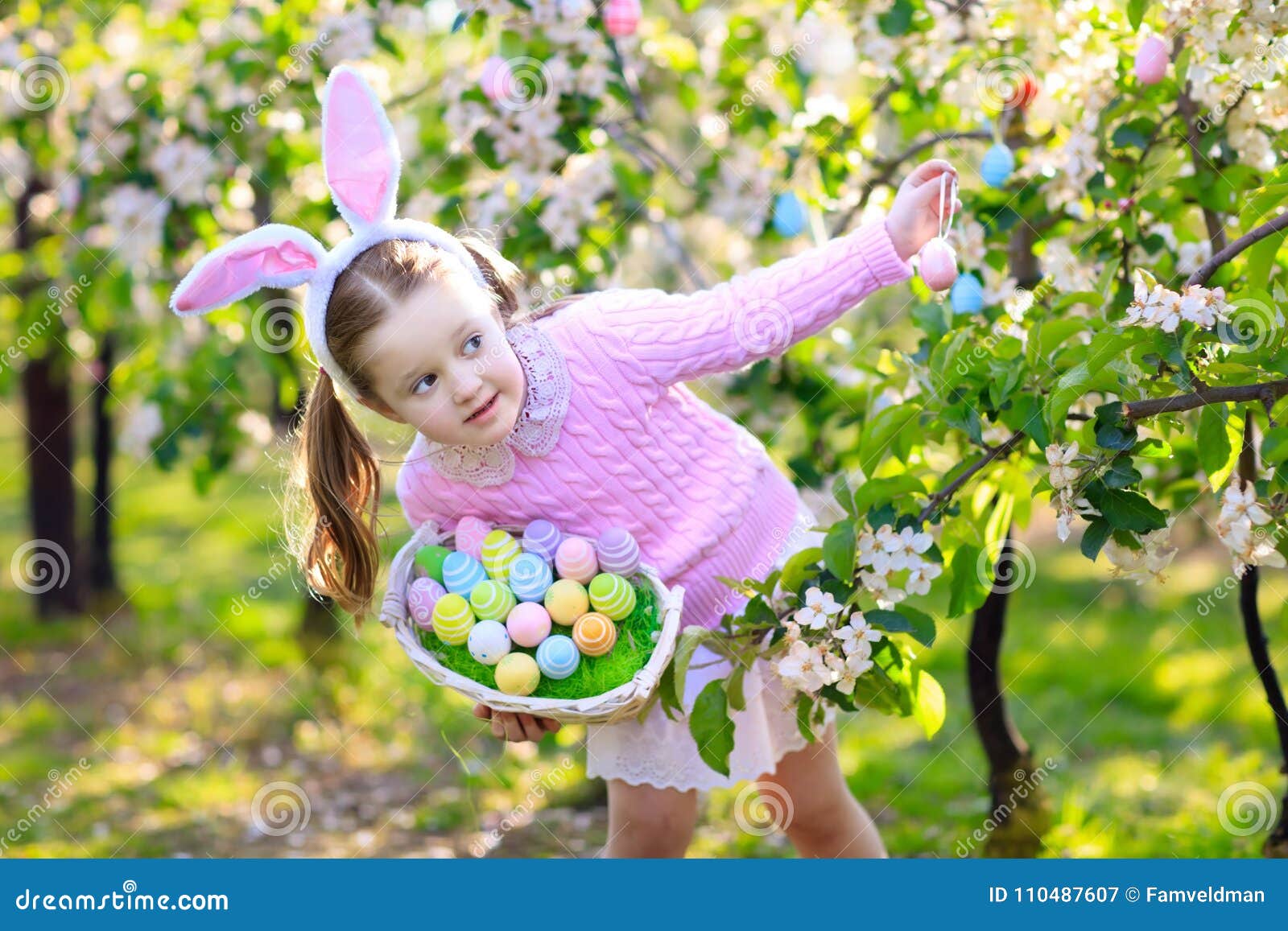 child with bunny ears on garden easter egg hunt