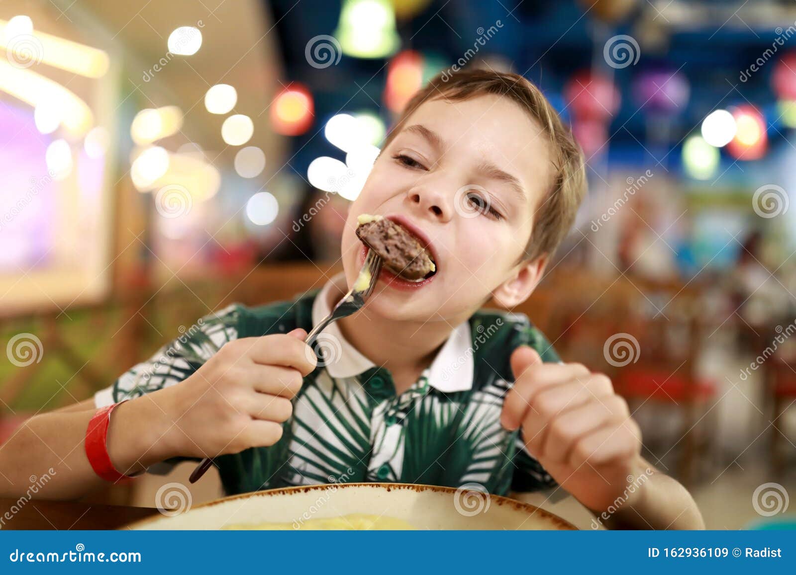 Child eating veal cutlet stock image. Image of dish 162936109