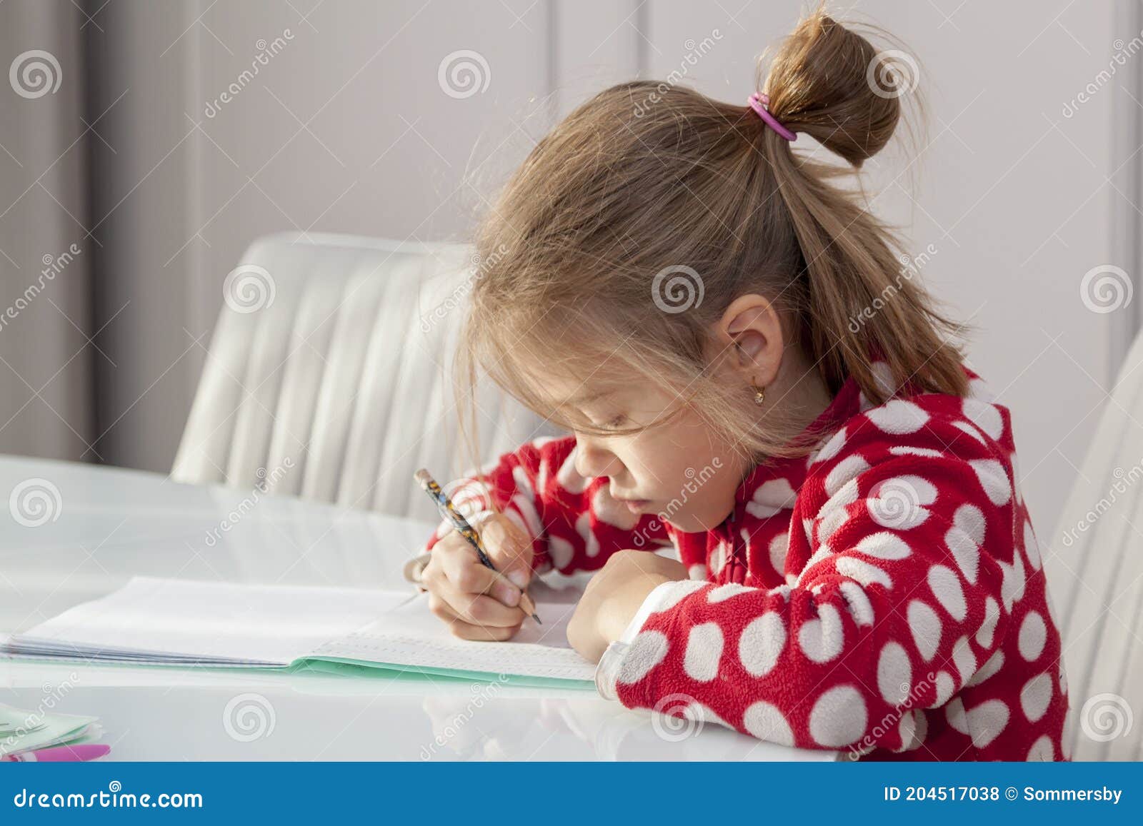 Child Girl Doing Homework Sitting at Kitchen Table, Learning at Home