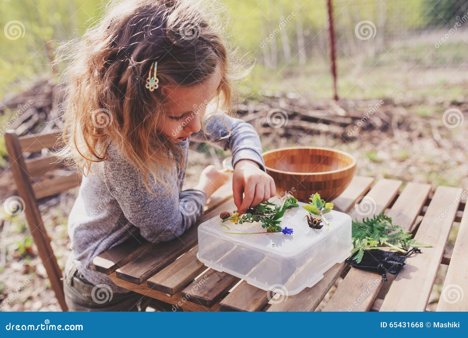 child girl exploring nature in early spring forest. kids learning to love nature. teaching children about seasons changing.