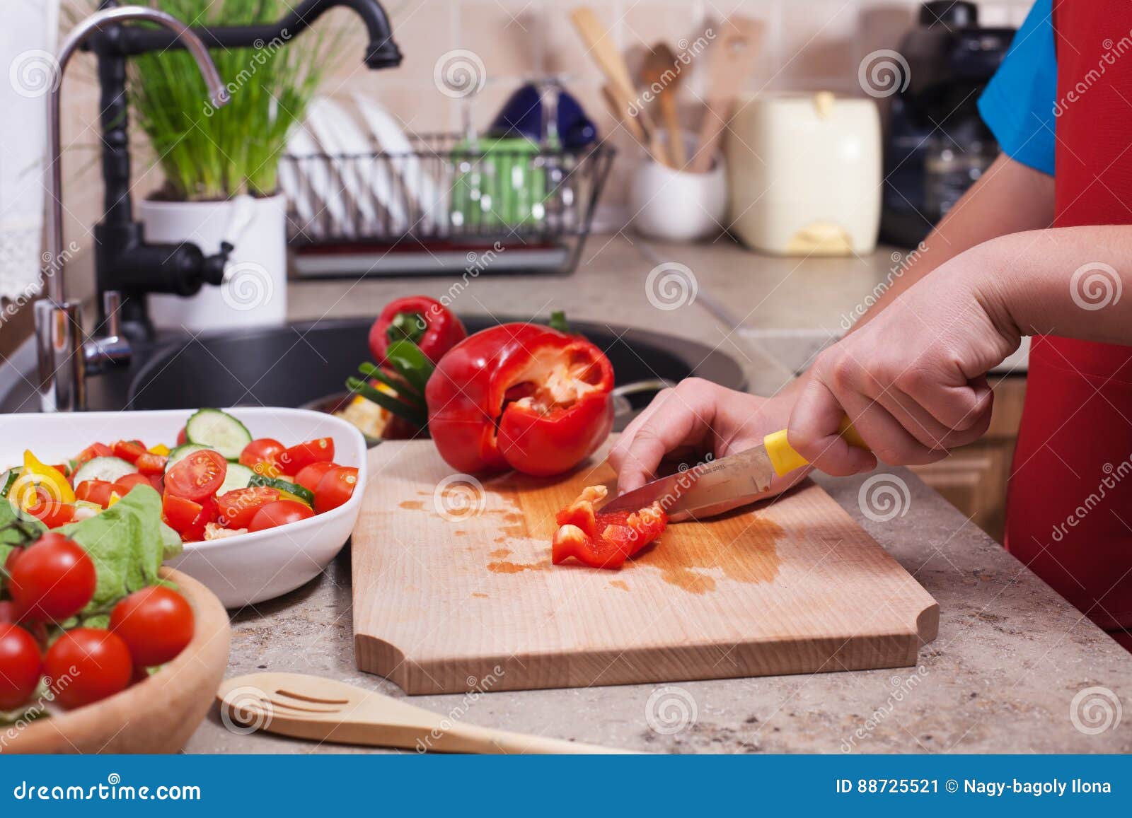 child hands chopping a red bellpepper for a fresh vegetables sal