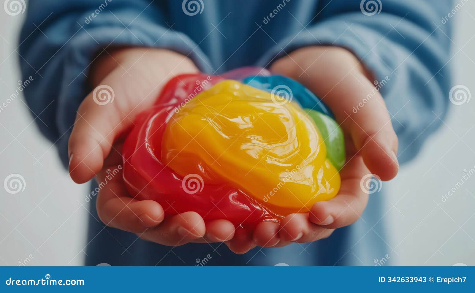 child hands holding multicolored slime on blurred background