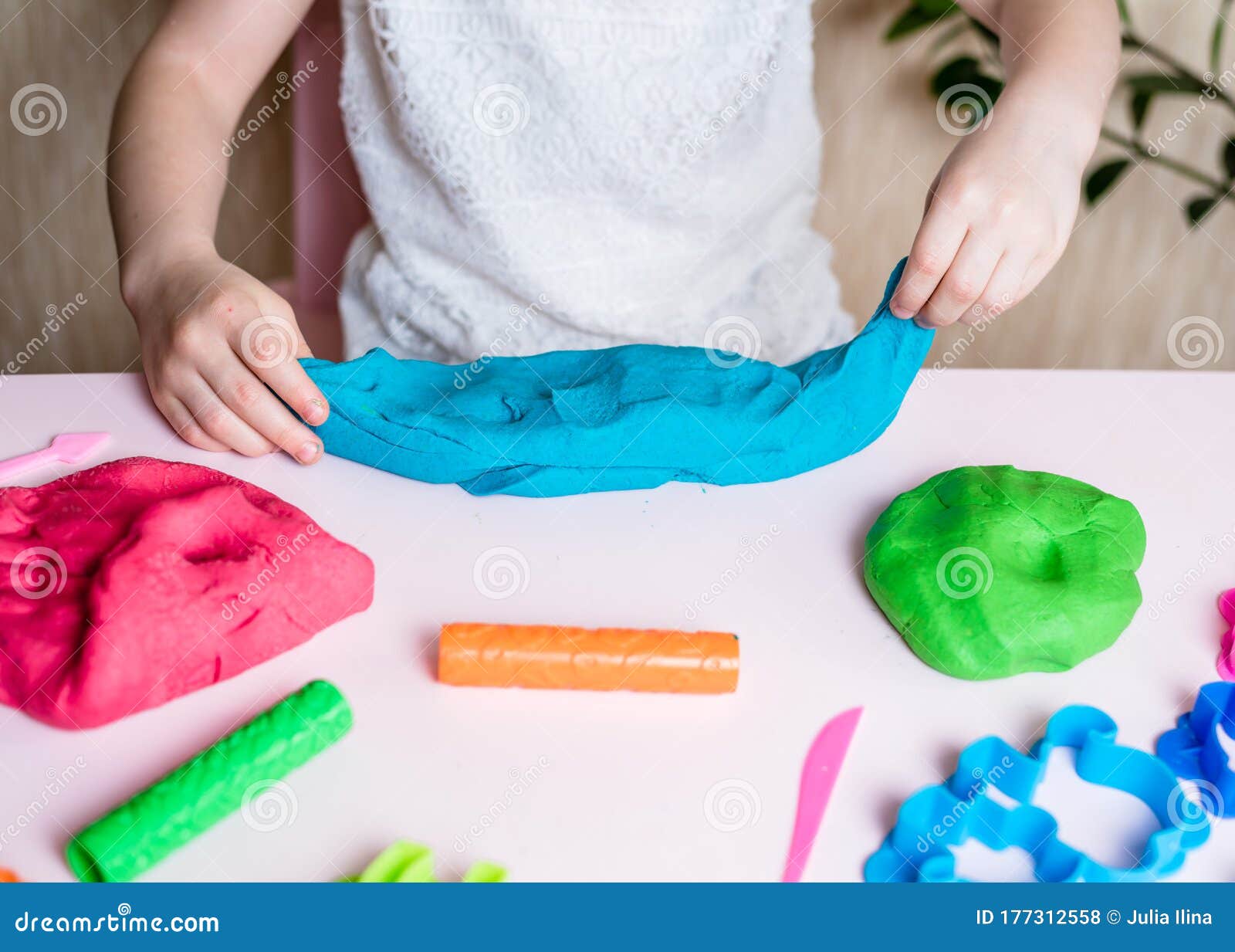 Child hands playing with colorful clay. Homemade plastiline