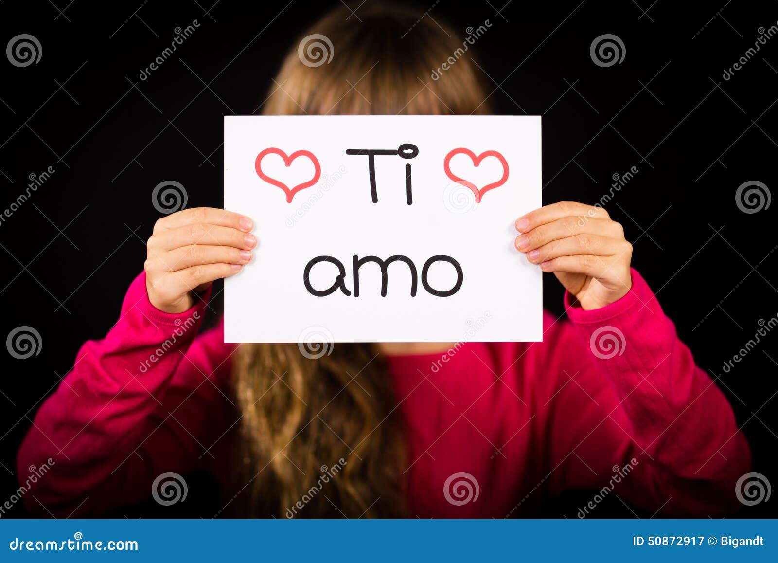 child holding sign with italian words ti amo - i love you