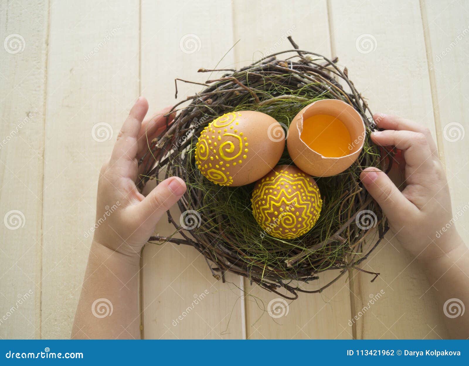 The Child Holds the Brown Egg with a Pattern. Painted Brown Eggs. Stock