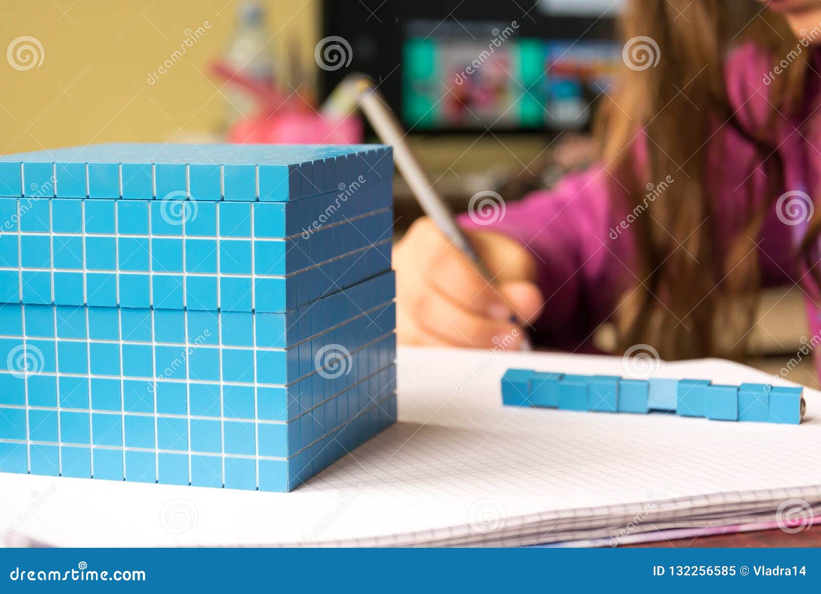 child learns math, volume and capacity. for learning model uses a three-dimensional cube.