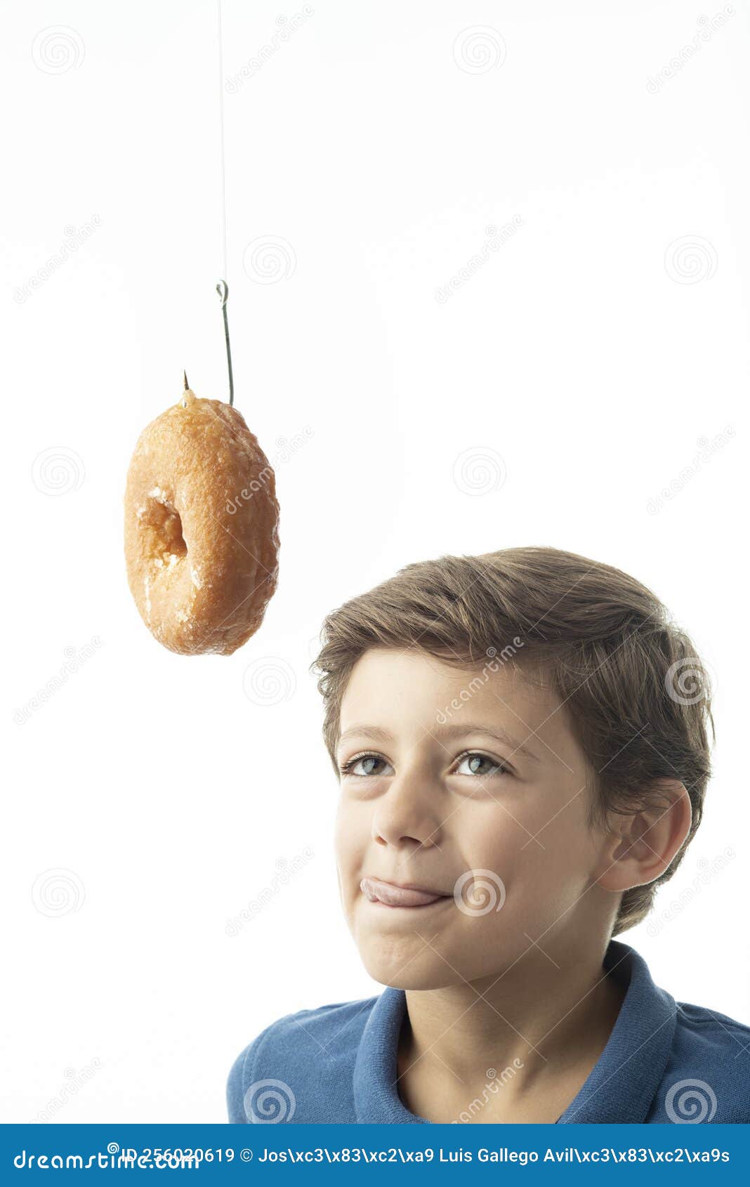 a child looks longingly at a doughnut hanging from a hook