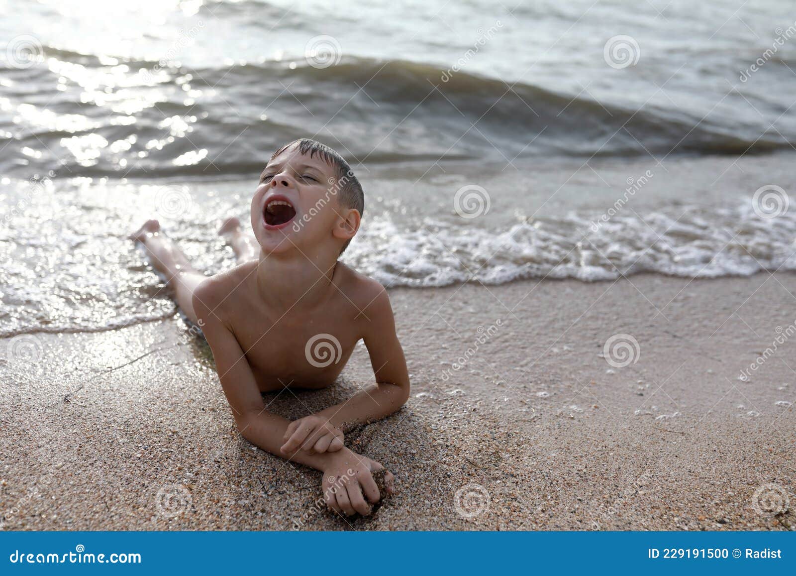 child lying on beach of azov sea