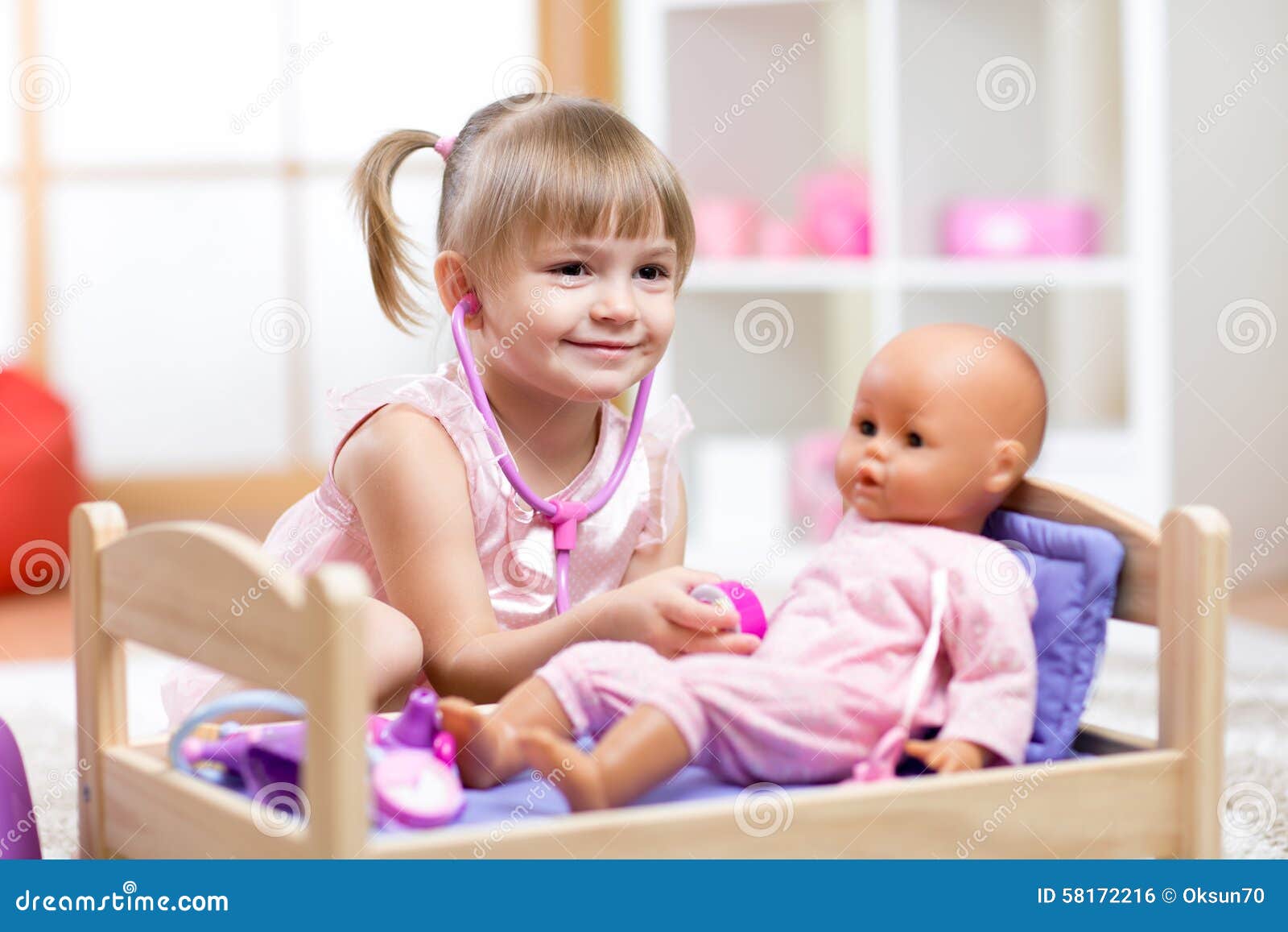 child playing doctor with doll toy