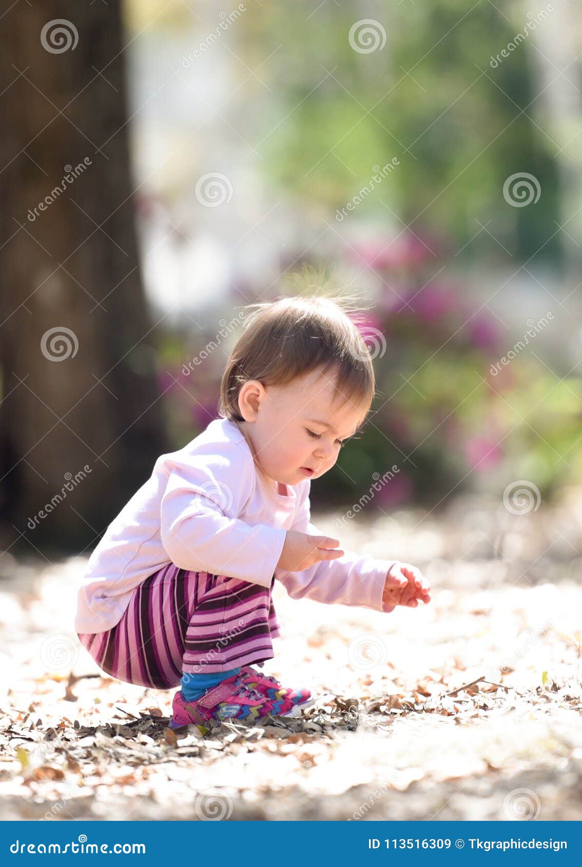 Child playing at a park picking up rocks and sticks