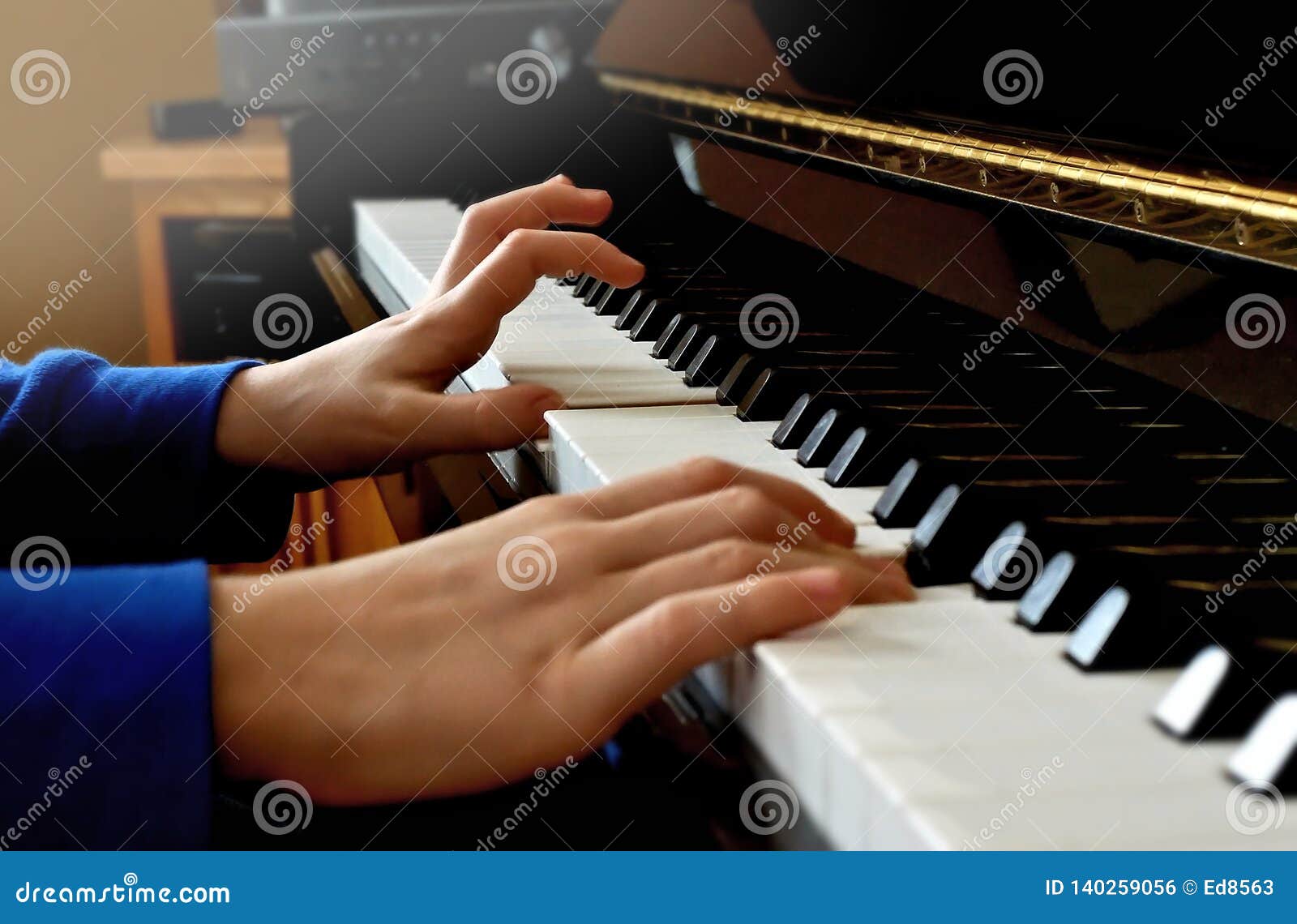 Child Playing Piano. Close Up Side View of Young Hands and Fingers