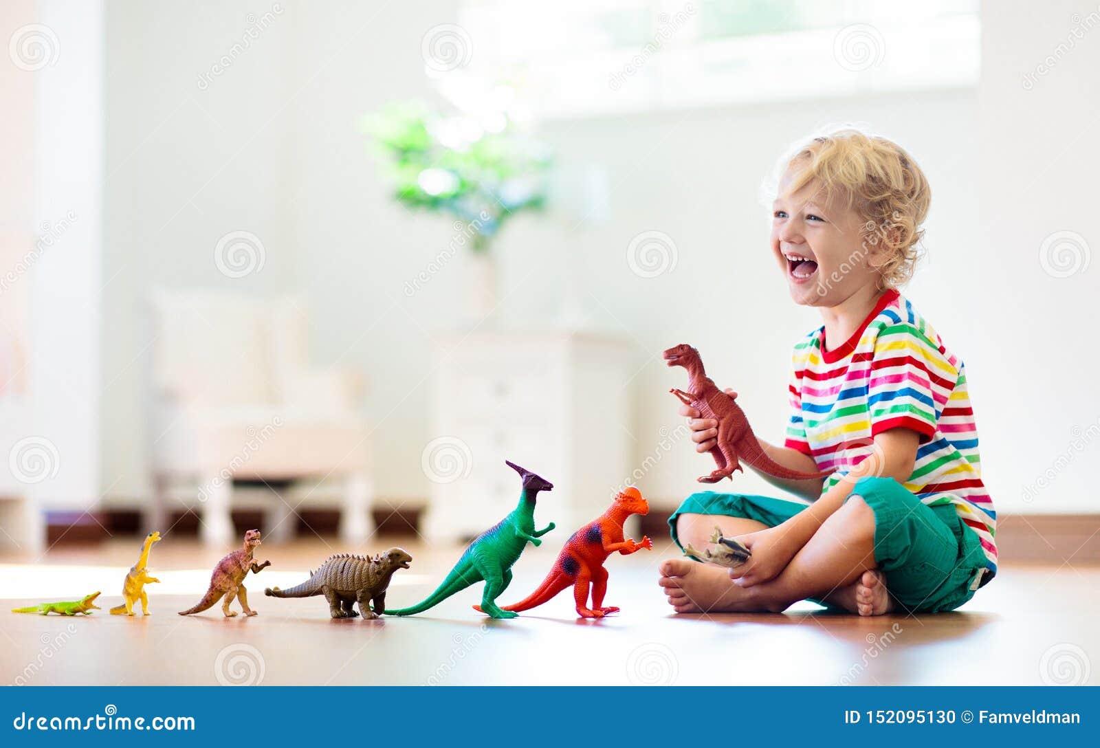 child playing with toy dinosaurs. kids toys