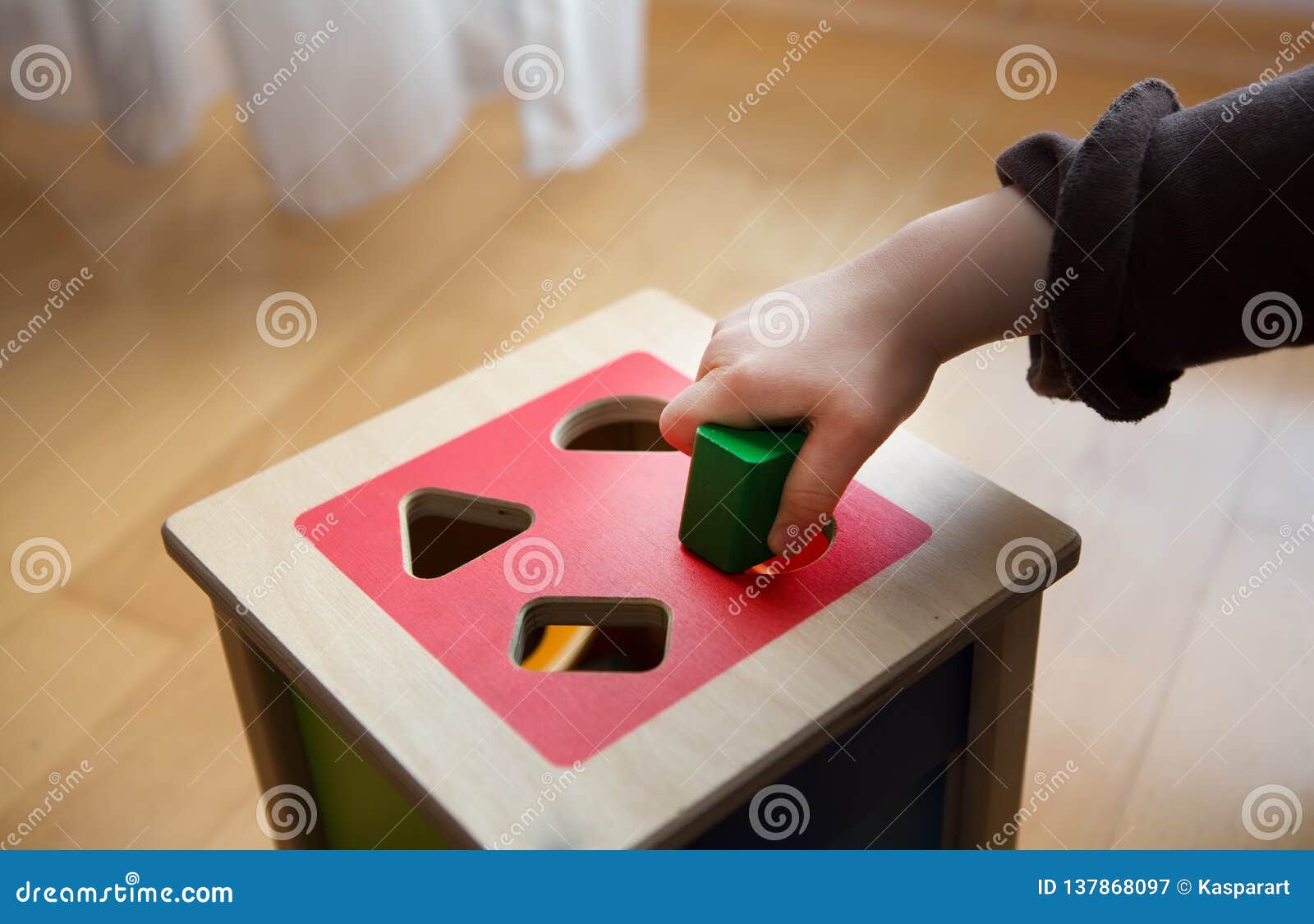 Child Playing with Wooden Bricks in Diffrent Shapes and Colors Trying