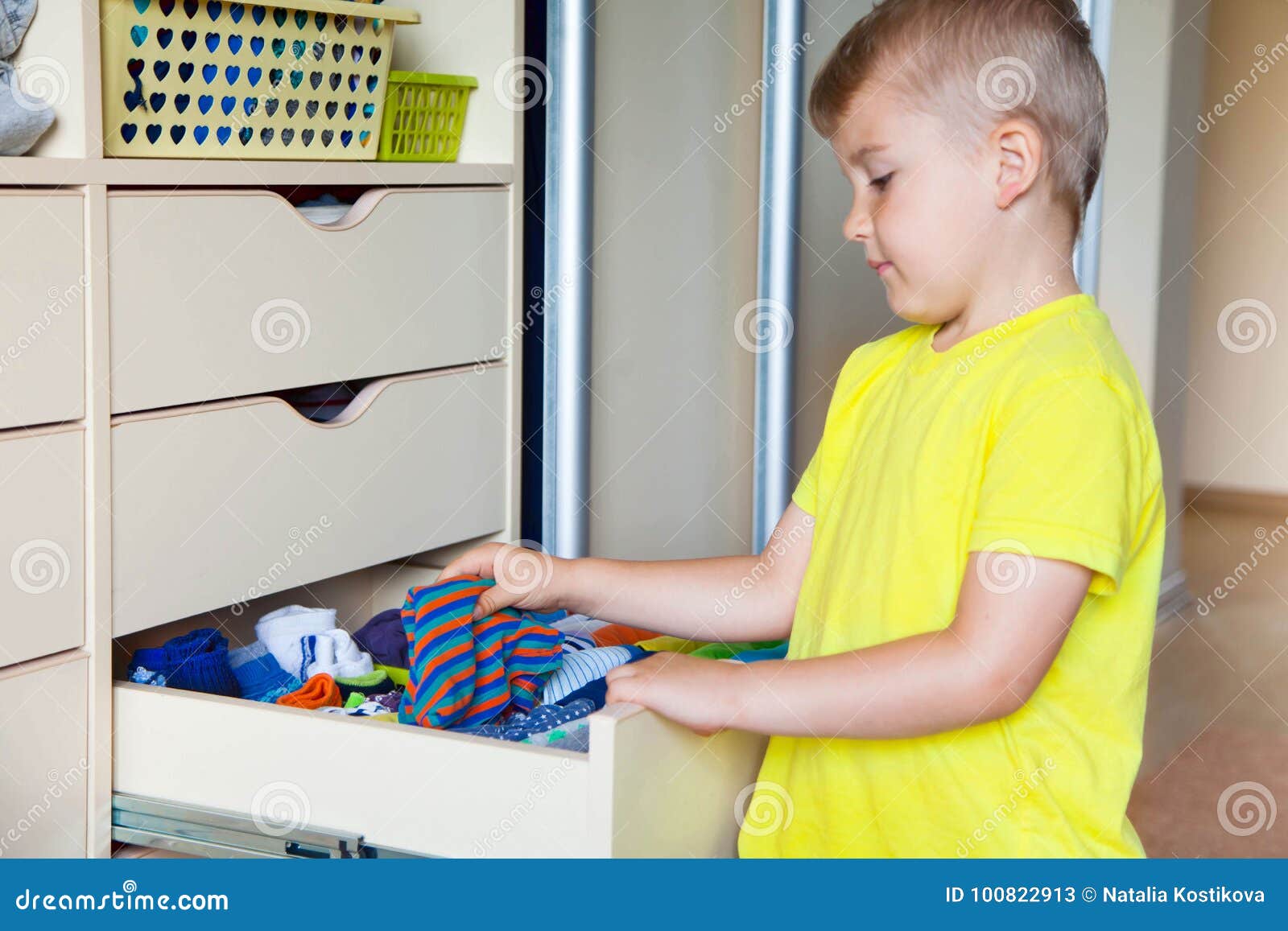 The Child Puts His Clothes on. the Boy Pulls the Tshirt Out of Stock