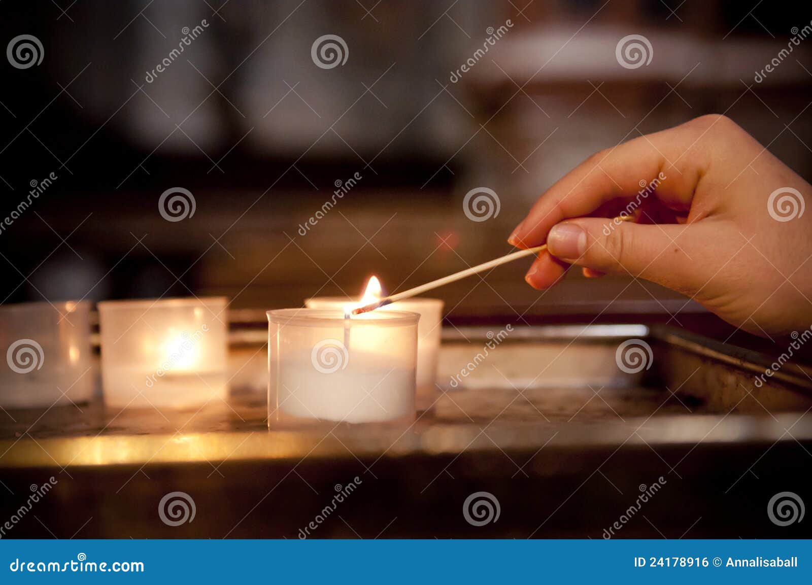 child's hand lighting a candle in church