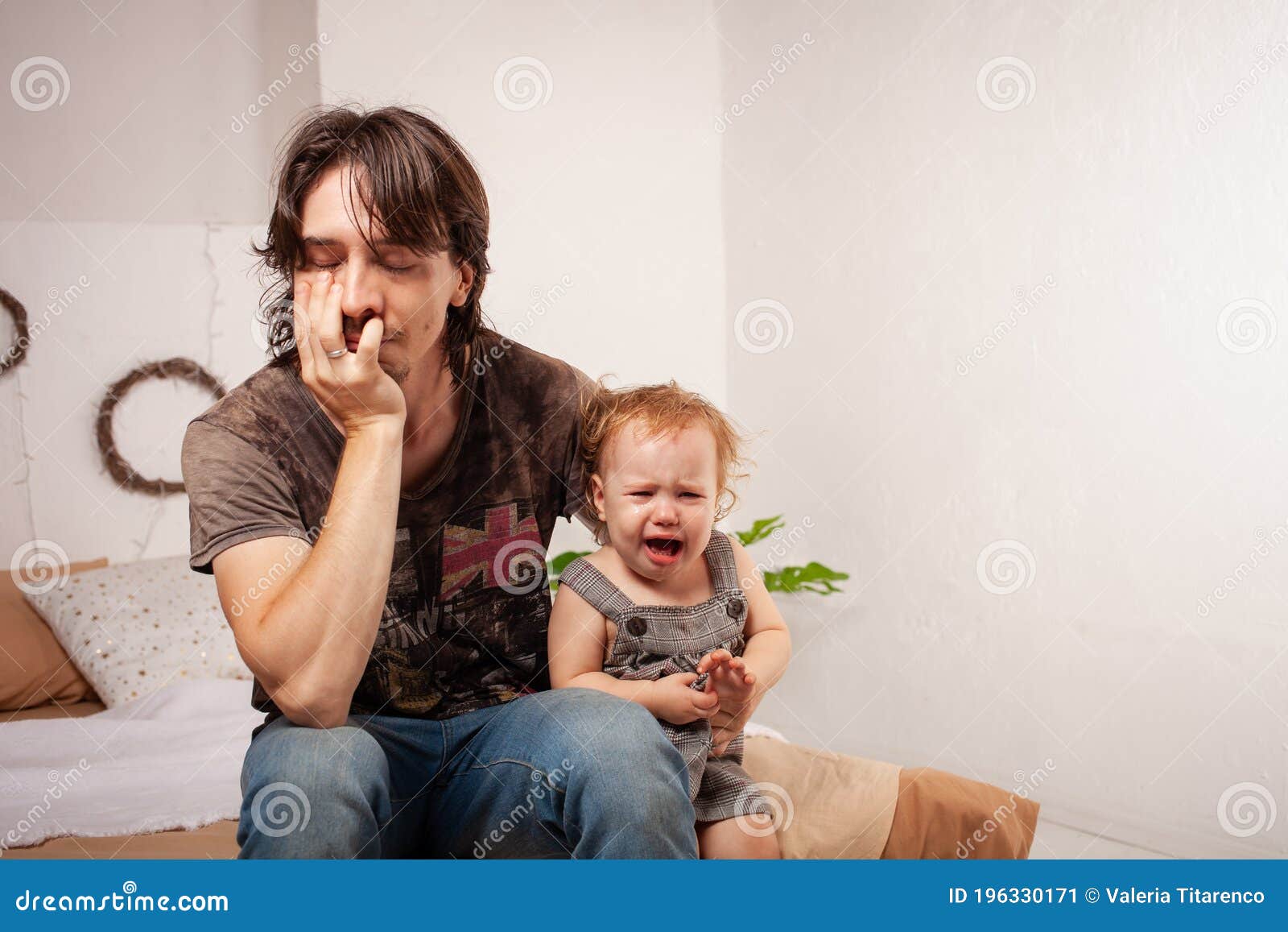 the child is screaming, hysterical. a tired dad doesn`t want to hear the baby. the parent is irritated, tired, wants to take a